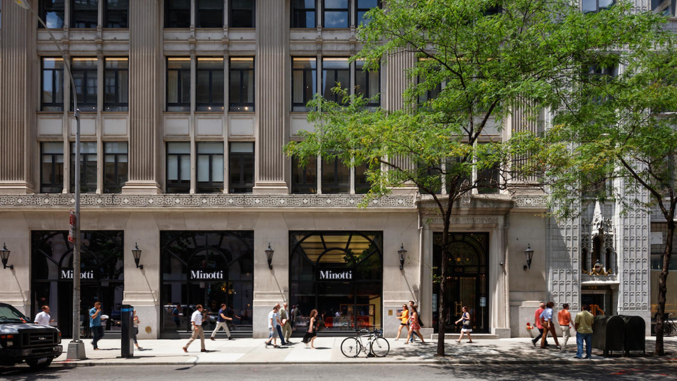 Exterior of first four floors of 136 Madison building with pedestrians on sidewalk in front
