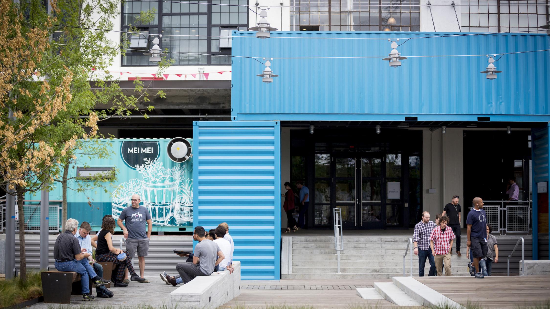 People outside in the common area at street level of The Innovation and Design Building
