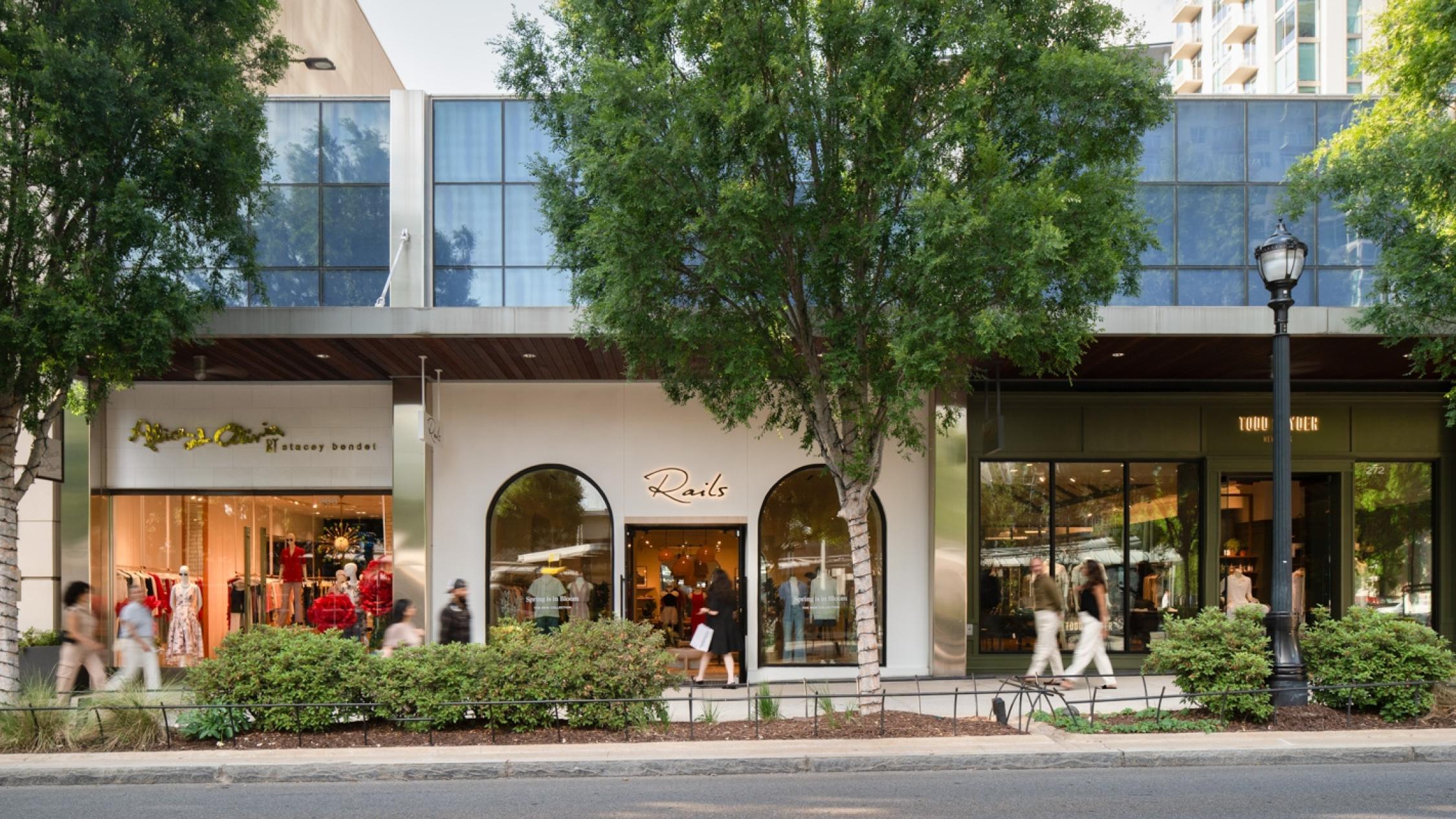 People walking on sidewalks in front of shops at Buckhead Village