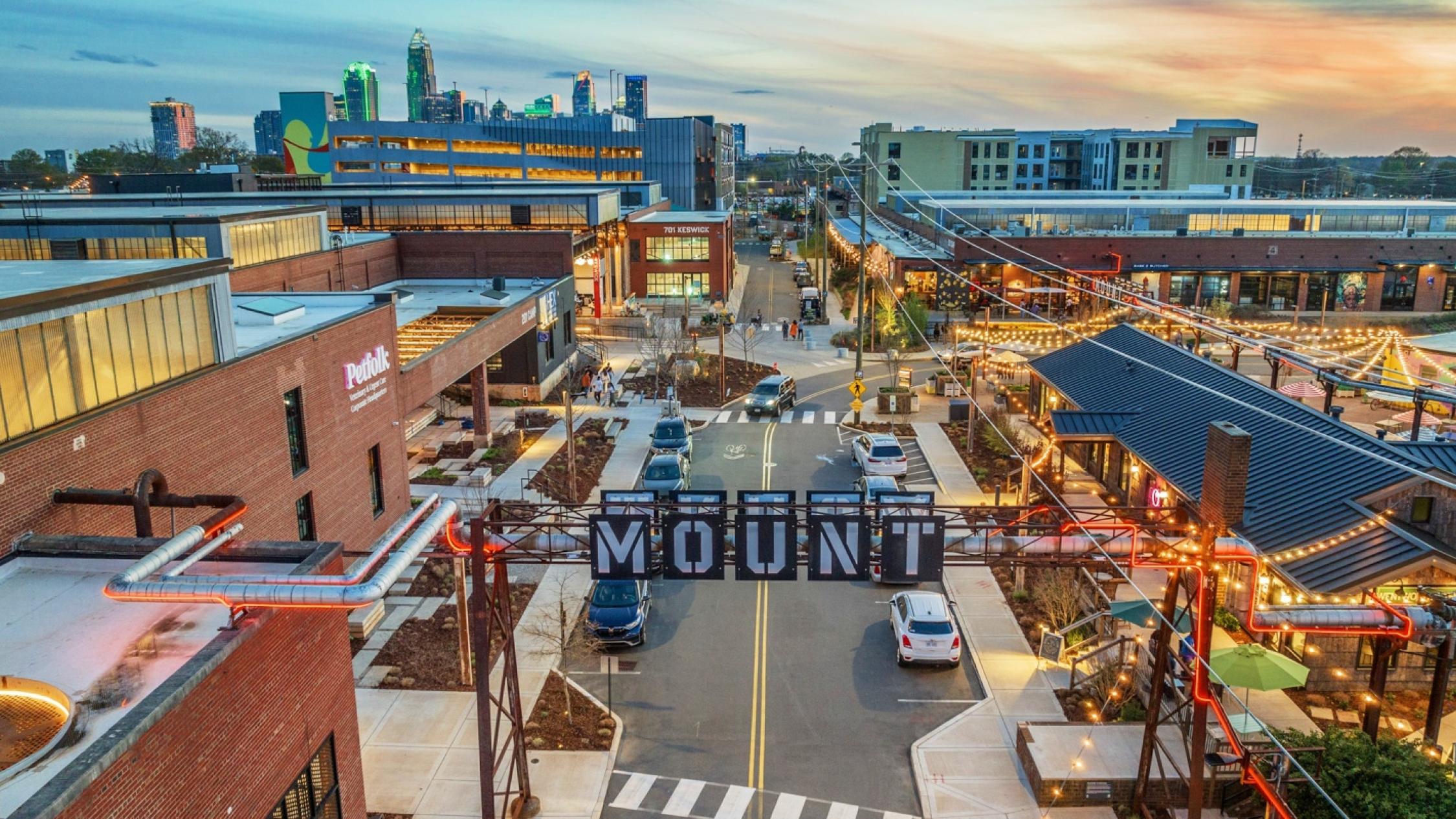 Aerial view of a street in Camp North End with the city skyline in the background