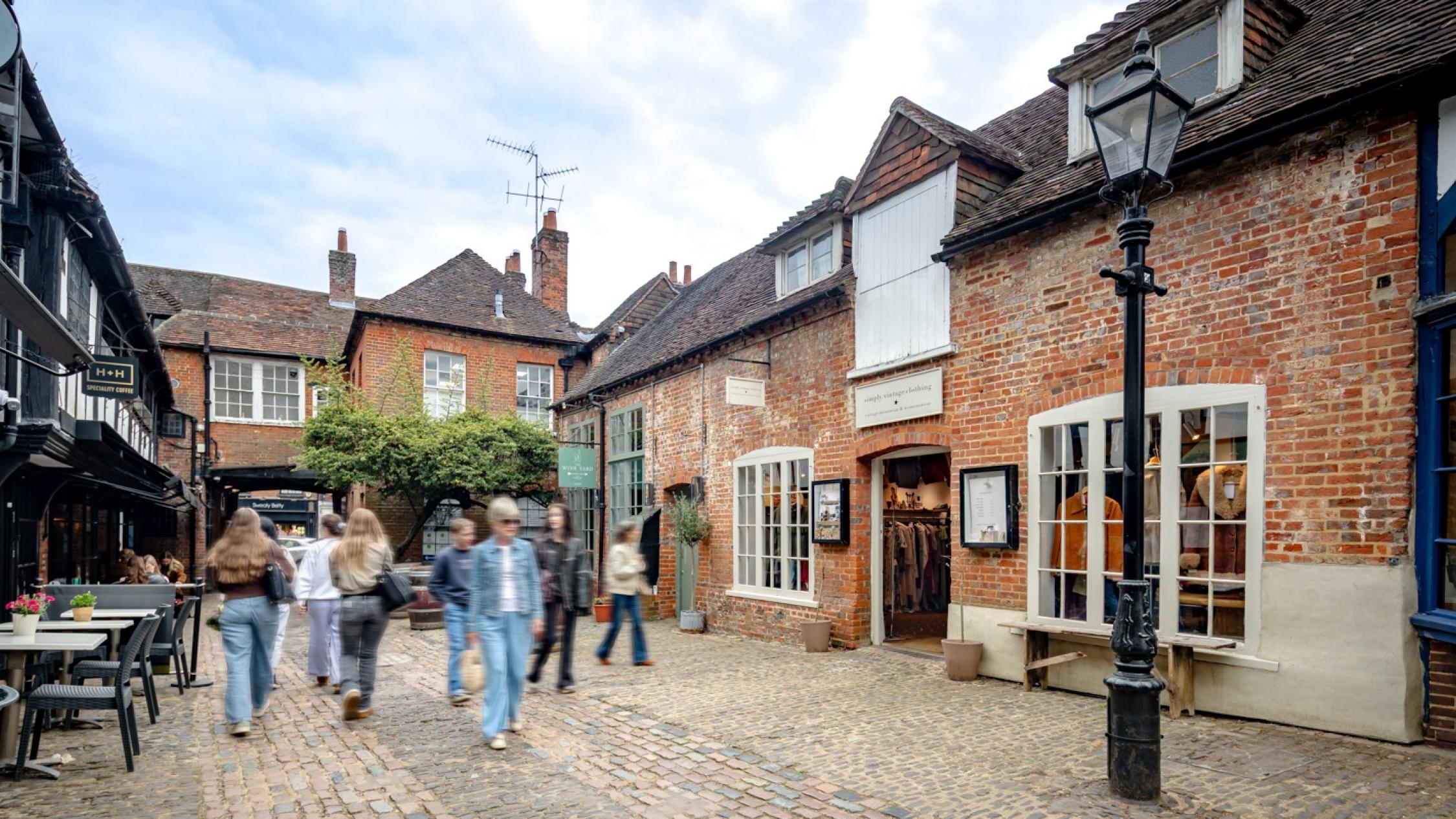 Visitors walking on a cobblestone street at the historic retail and residential property