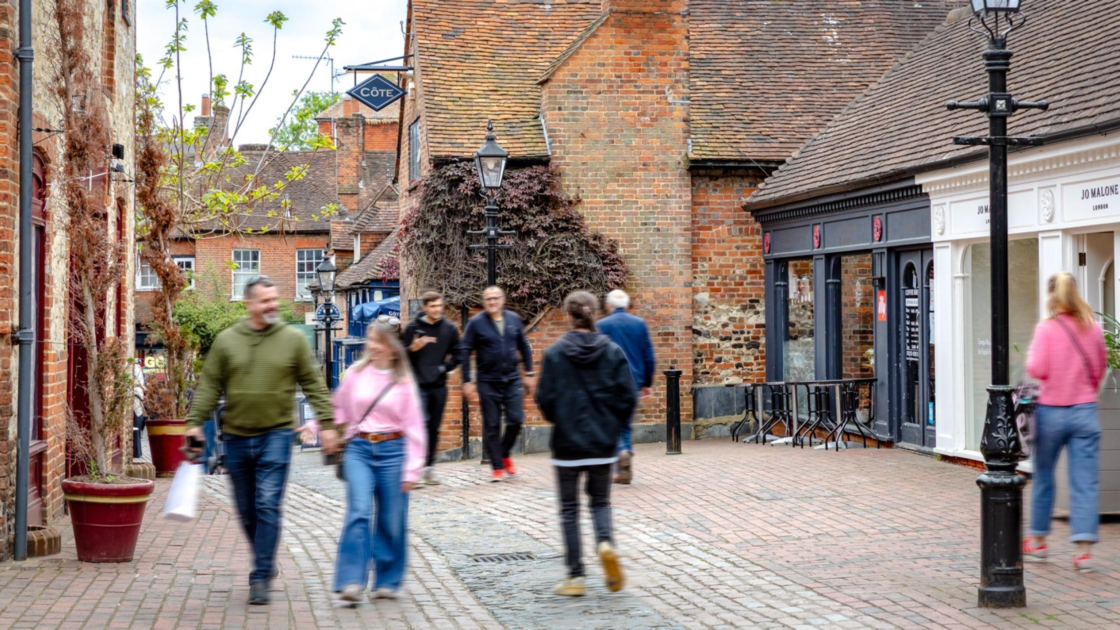 Visitors walking on a cobblestone street at the historic retail and residential property