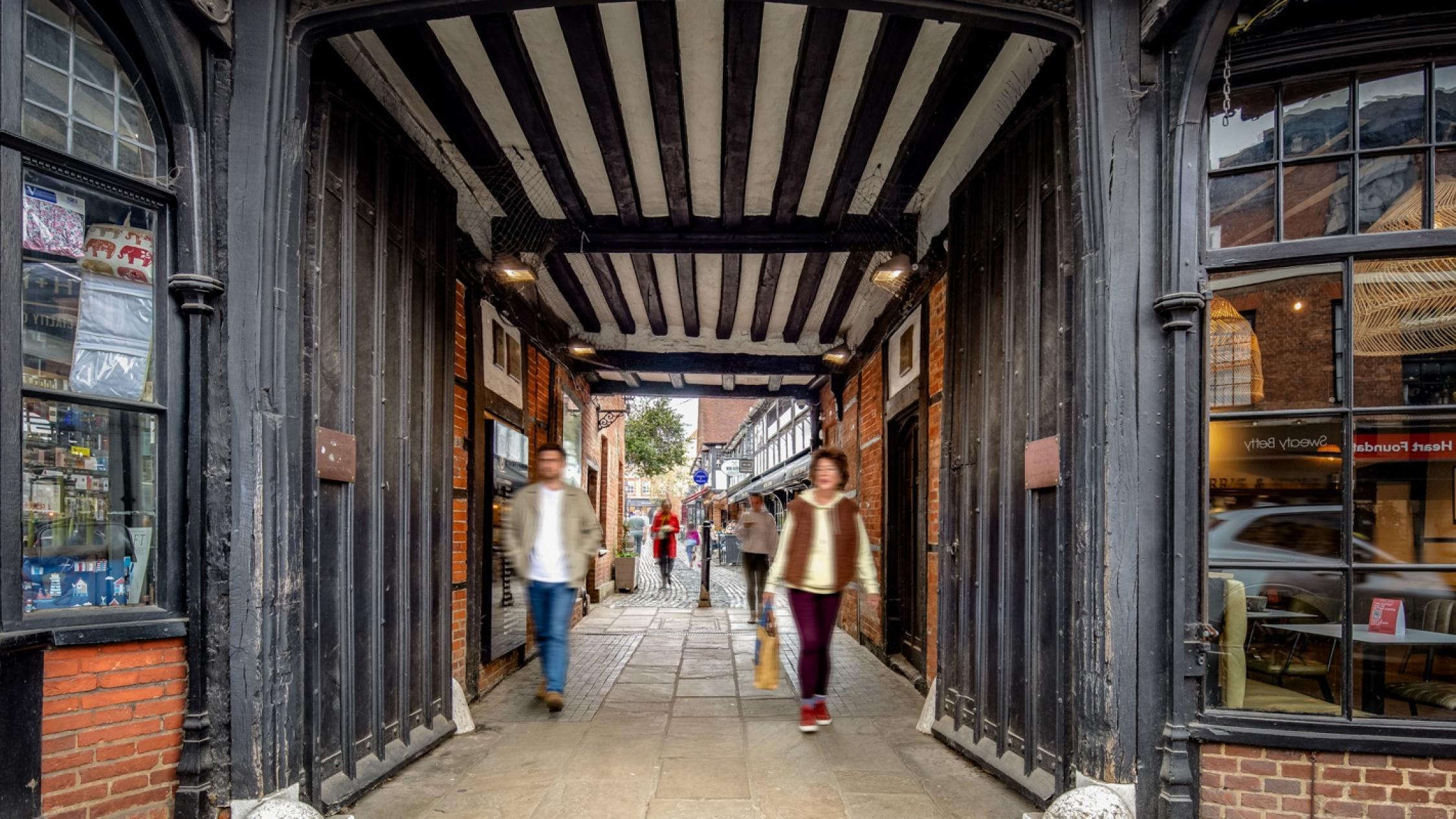 Visitors walking on a cobblestone street at the historic retail and residential property