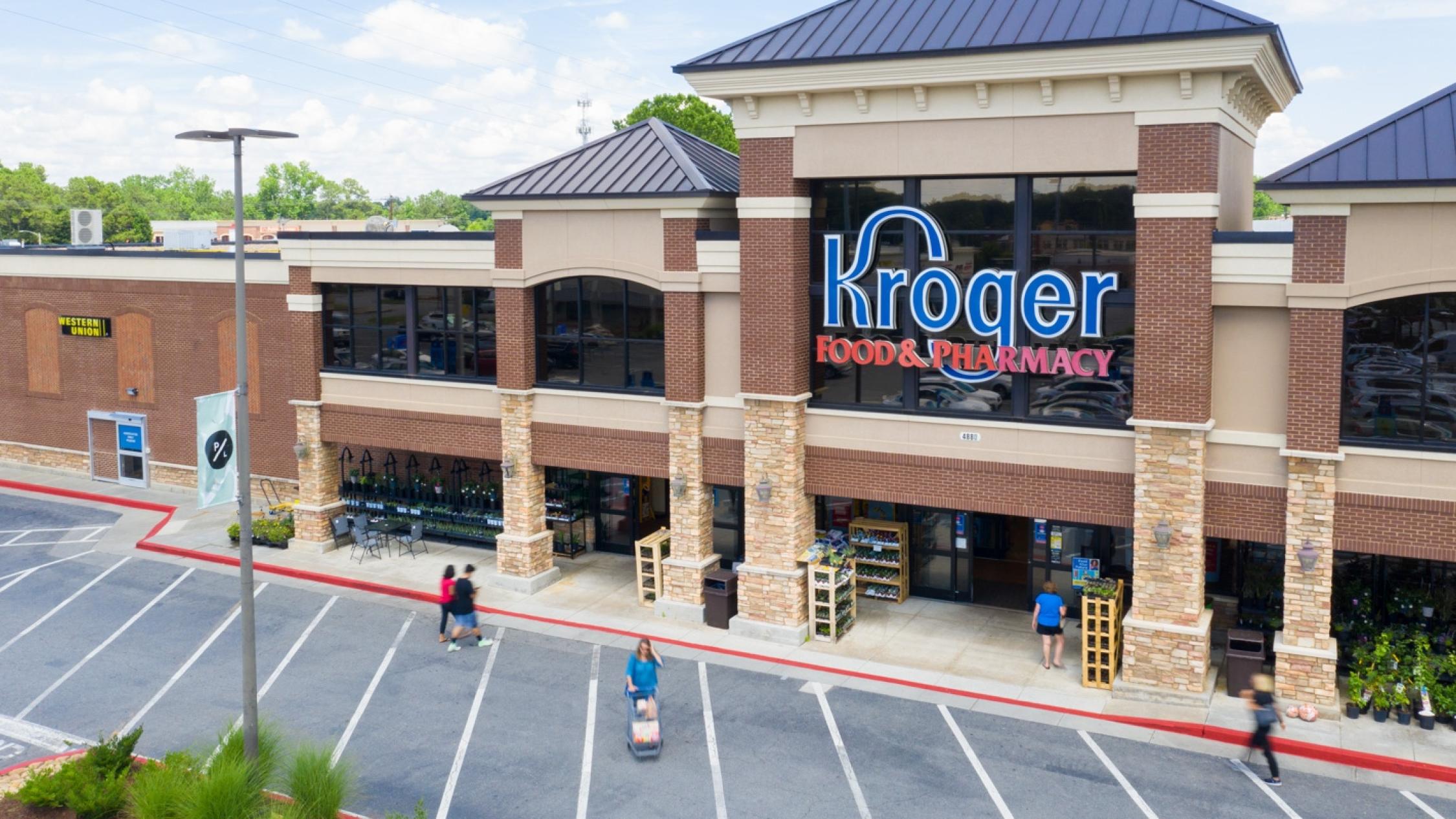 Low aerial view of the Kroger store exterior facade with pedestrians in driveway at Parkaire Landing