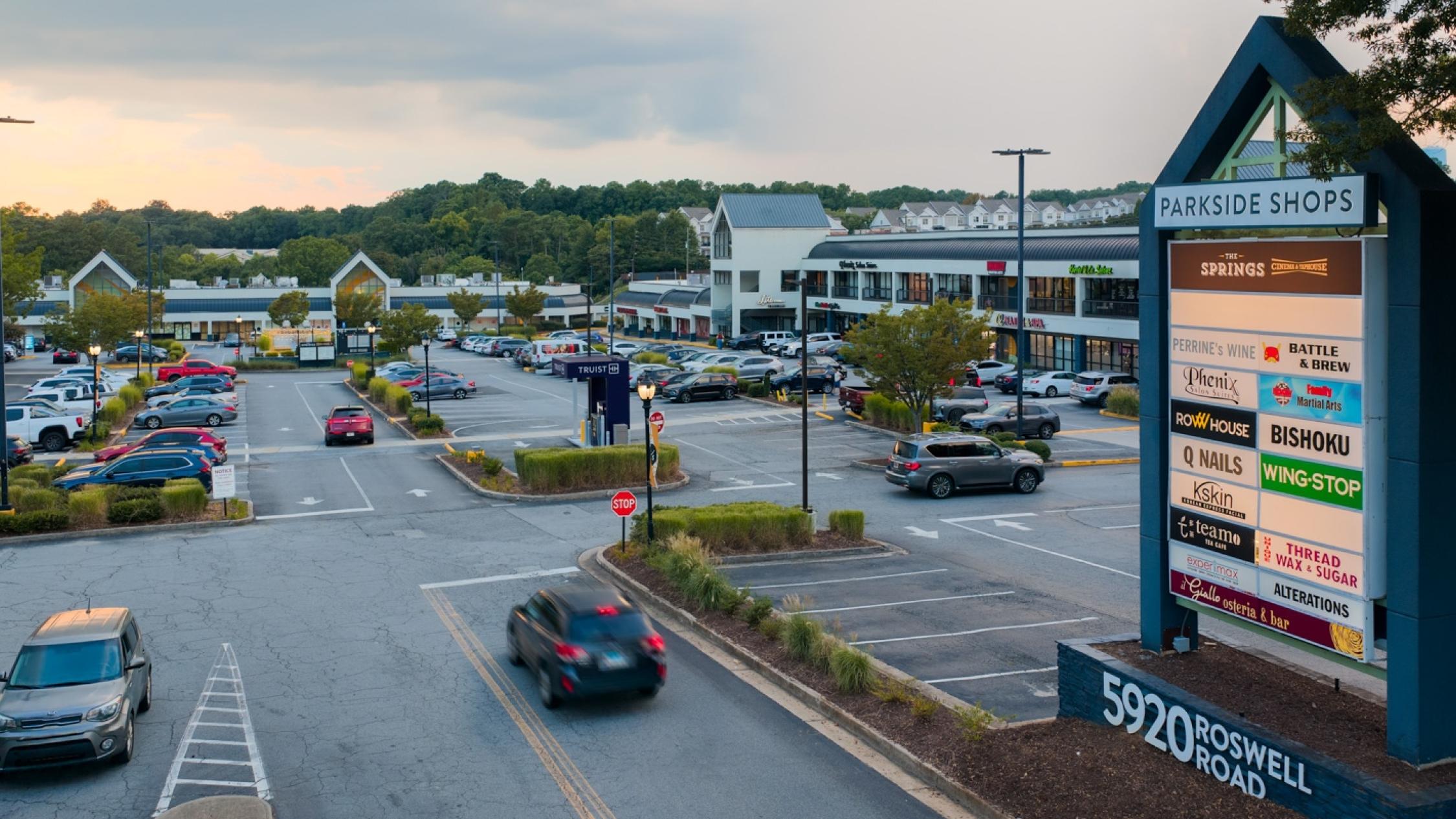 View of monument sign with cars entering and leaving the parking lot at Parkside Shops