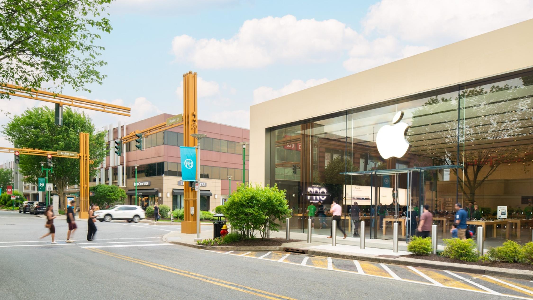 Visitors crossing the street and walking on sidewalks in front of shops at Ridge Hill