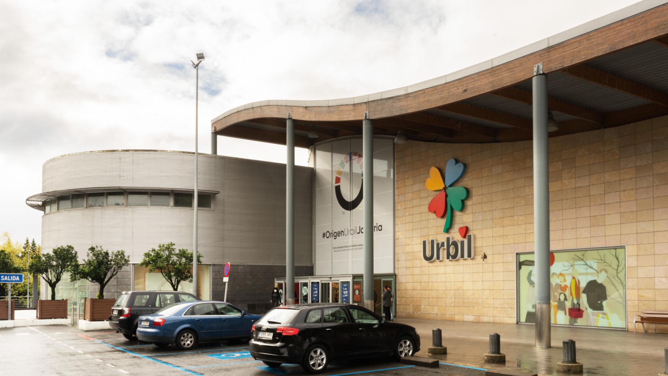 Urbil façade with cars parked near entrance