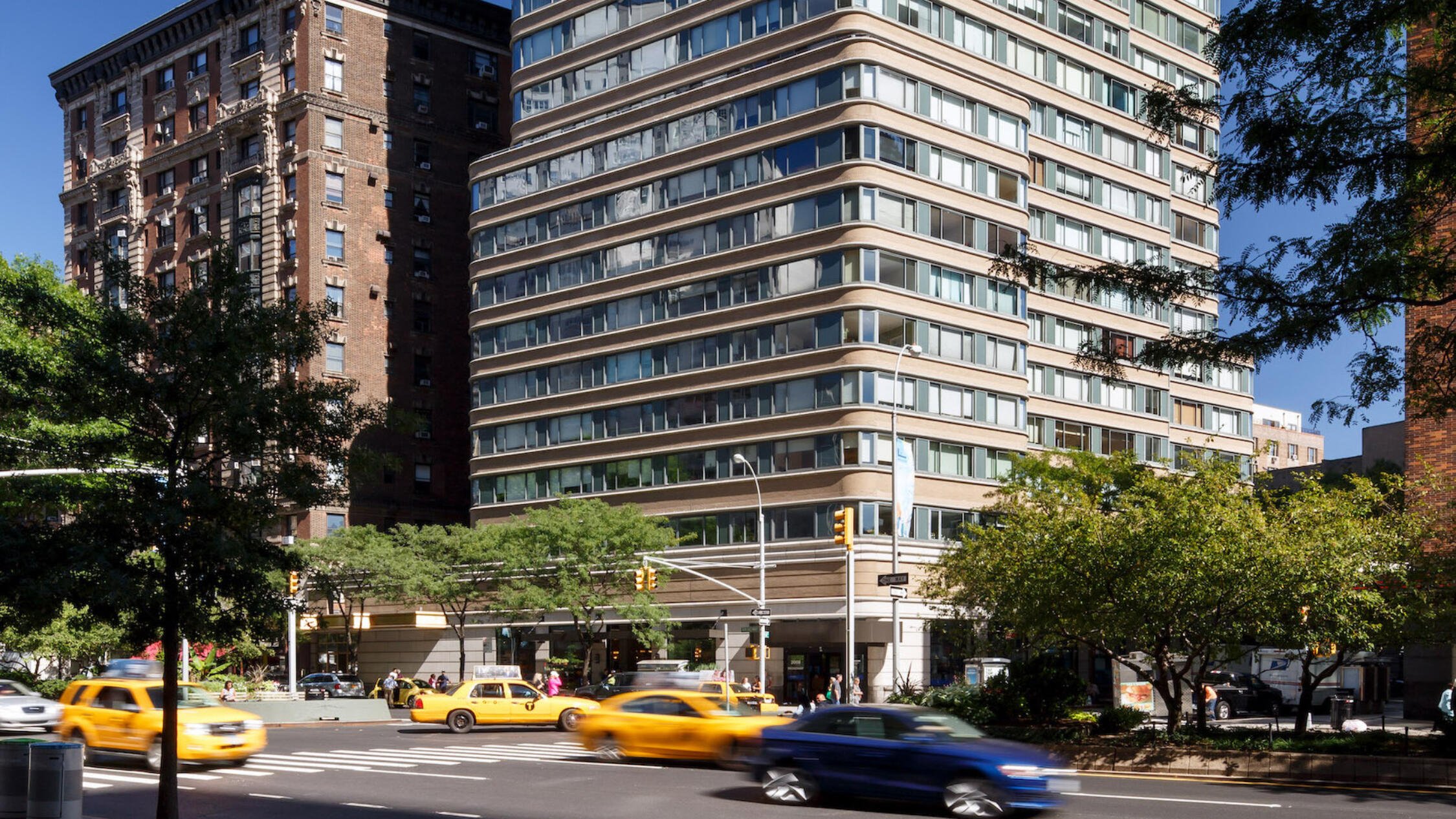 2000 Broadway building exterior with cars on tree lined street