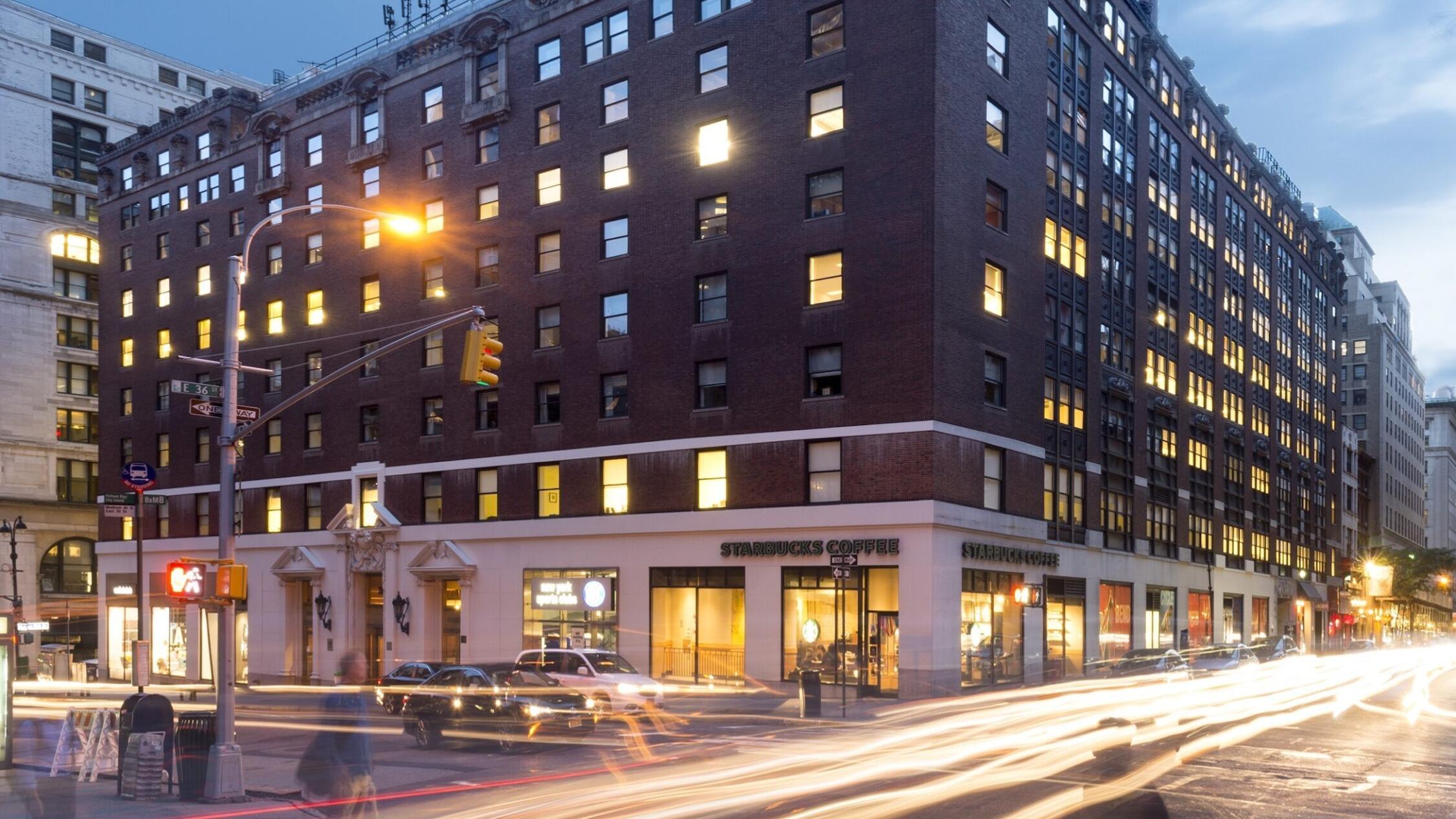 200 Madison building facade at dusk with motion blurred car headlights streaking along street