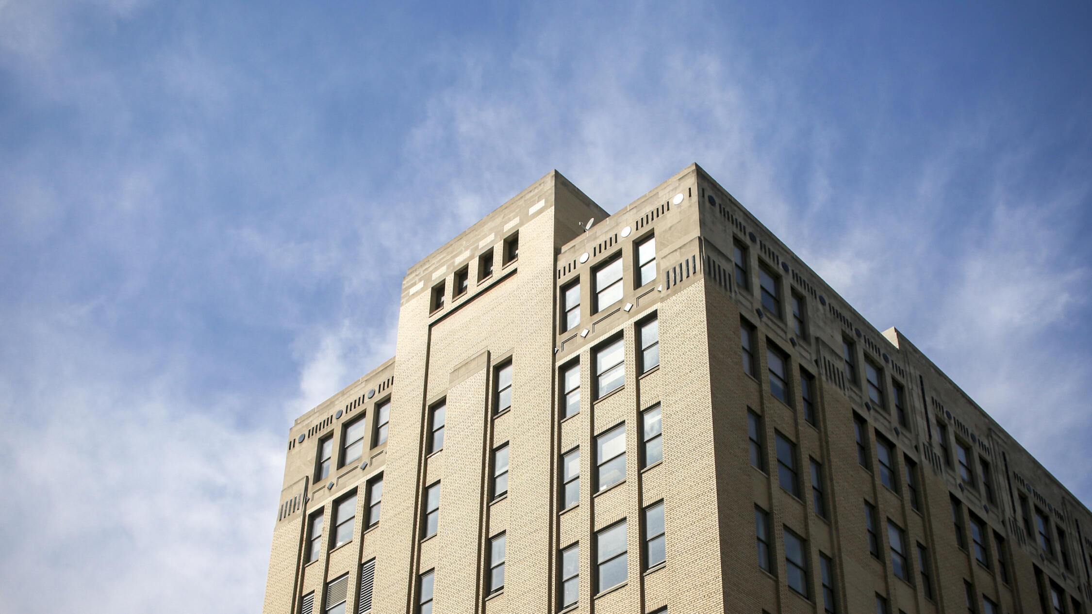 260 East 161st Street building upper floors framed against cloudy blue sky