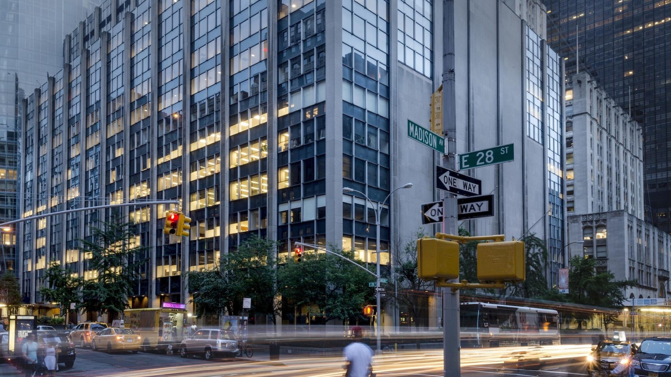 63 Madison exterior at dusk with motion blurred headlights streaking by on street