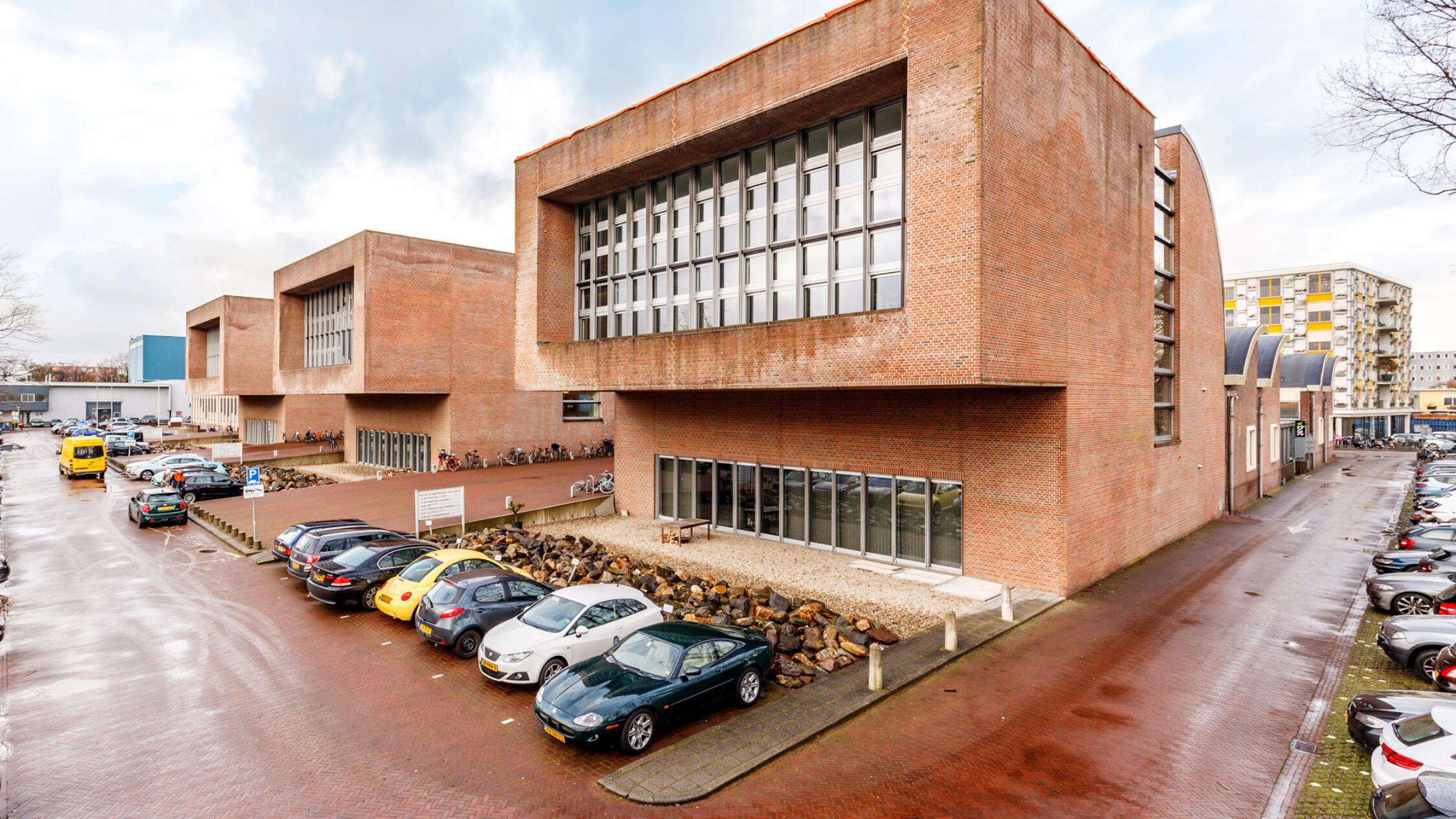 A Factorij exterior with cars parked in lots facing buildings