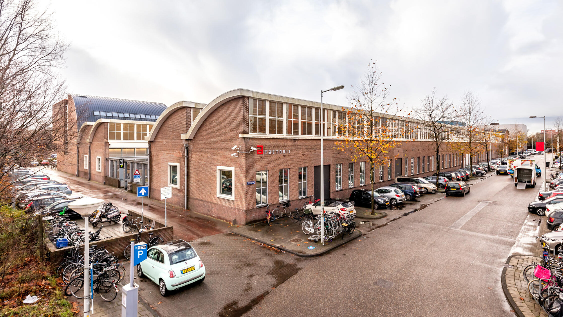 A Factorij exterior with cars parked in lots facing buildings