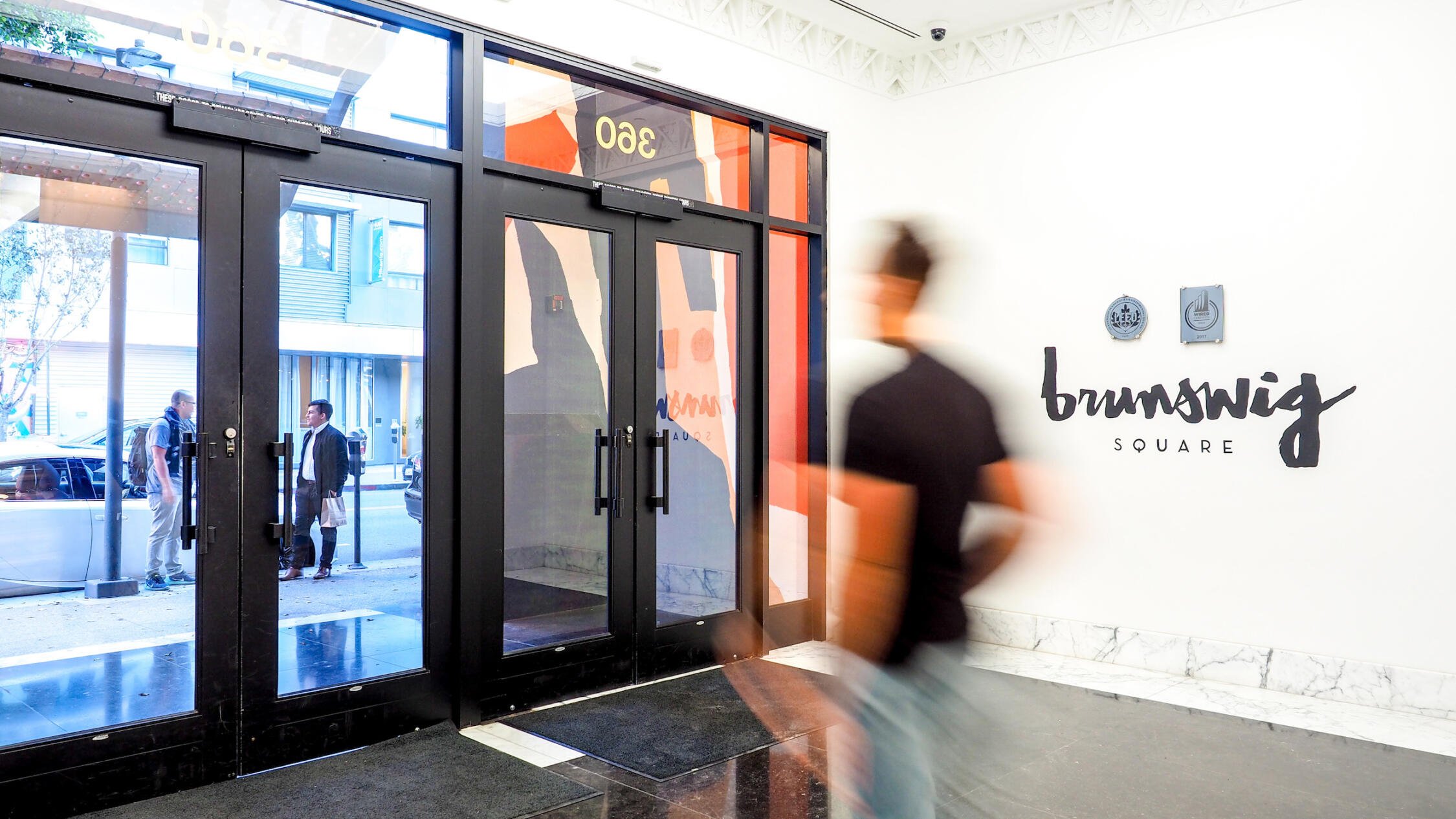 Brunswig Square lobby with visitor walking towards doors