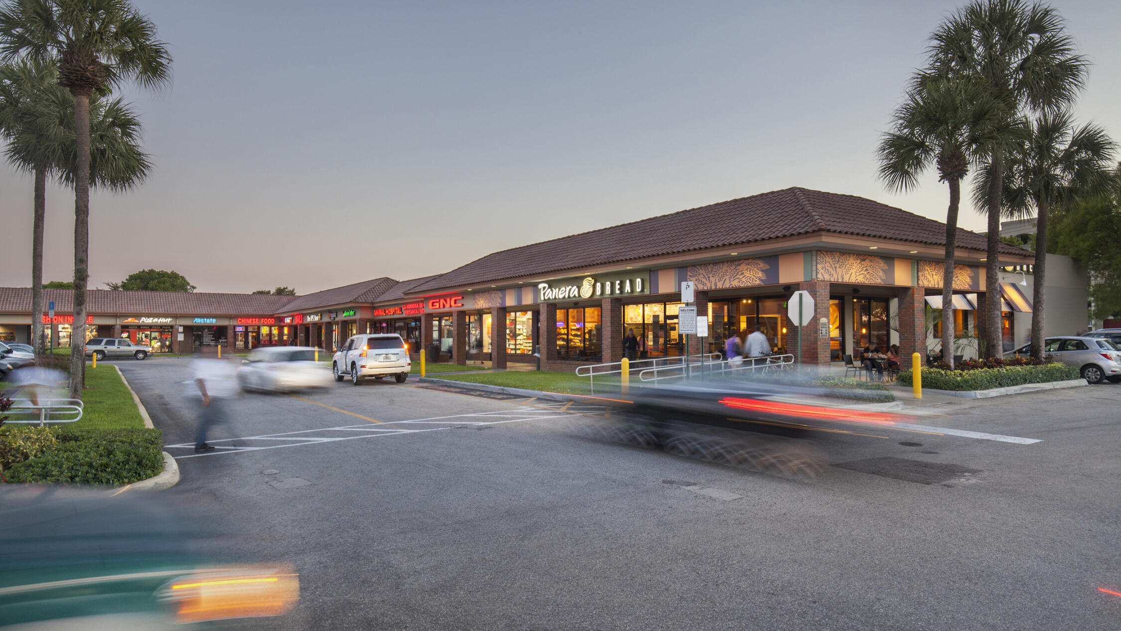 Country Club Plaza exterior with rows of shops and cars driving in parking lot