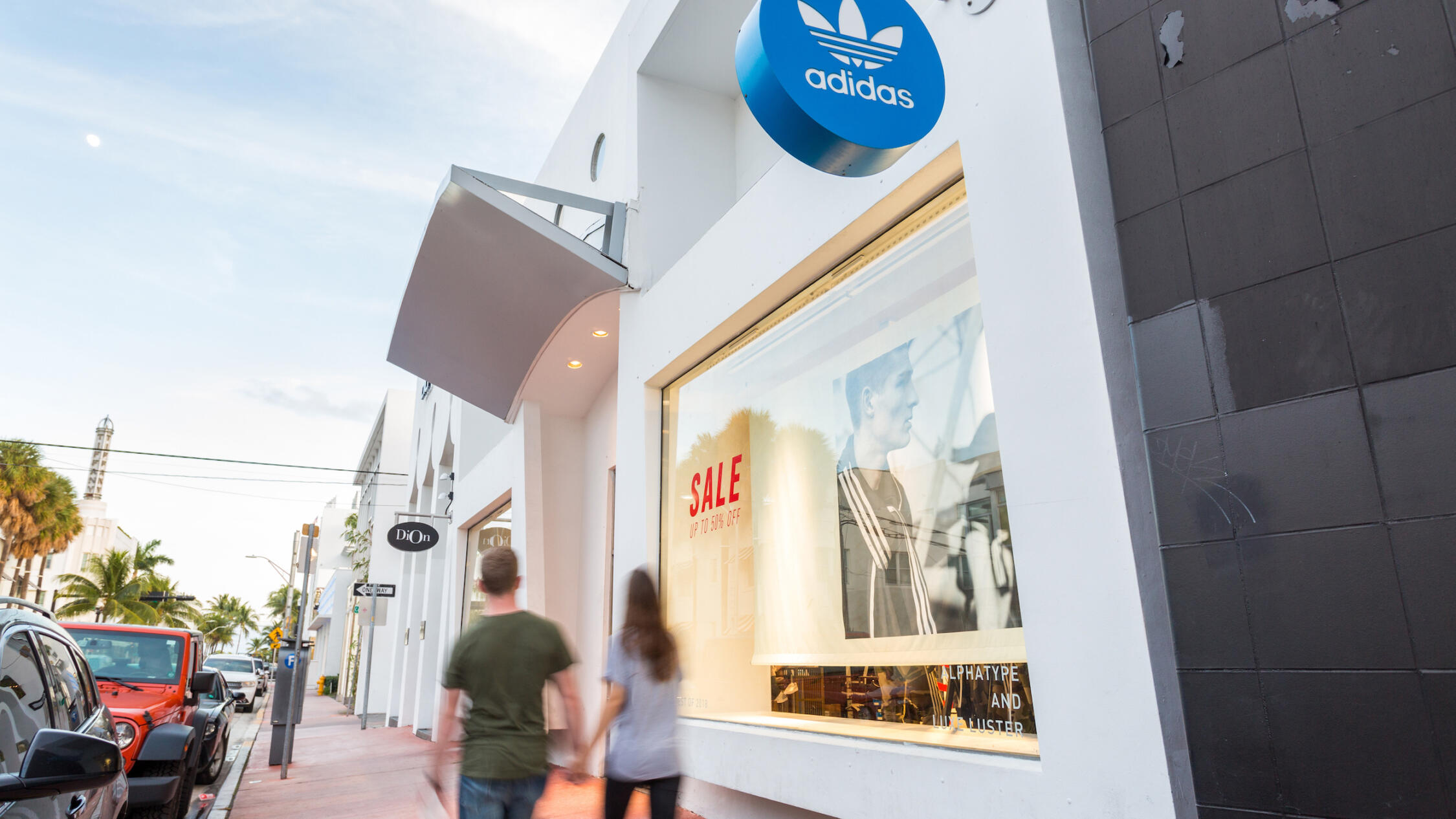 People walking by Adidas at Collins Avenue Collection