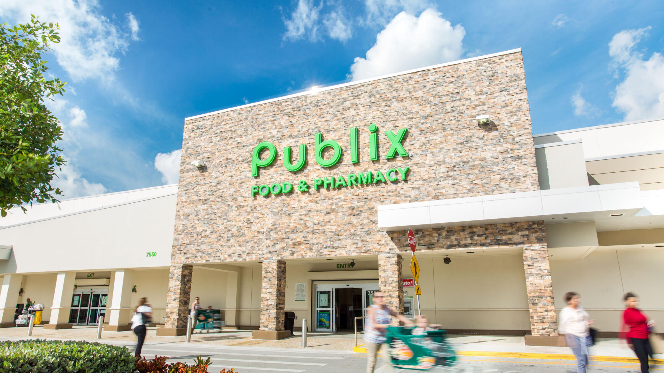 Doral Commons grocery store exterior with pedestrians crossing driveway