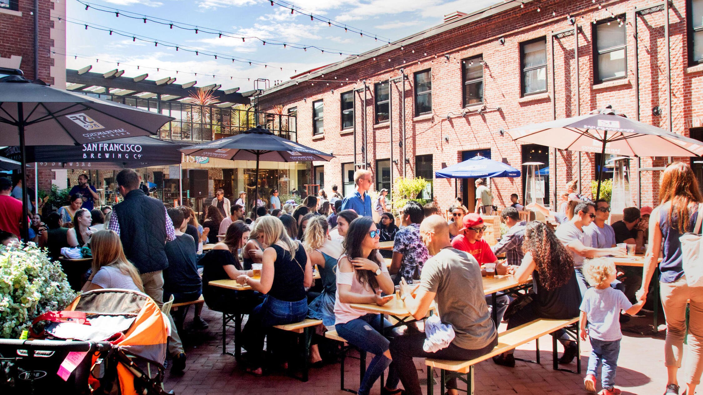 Ghirardelli Square restaurant patio with guests seated at tables under umbrellas