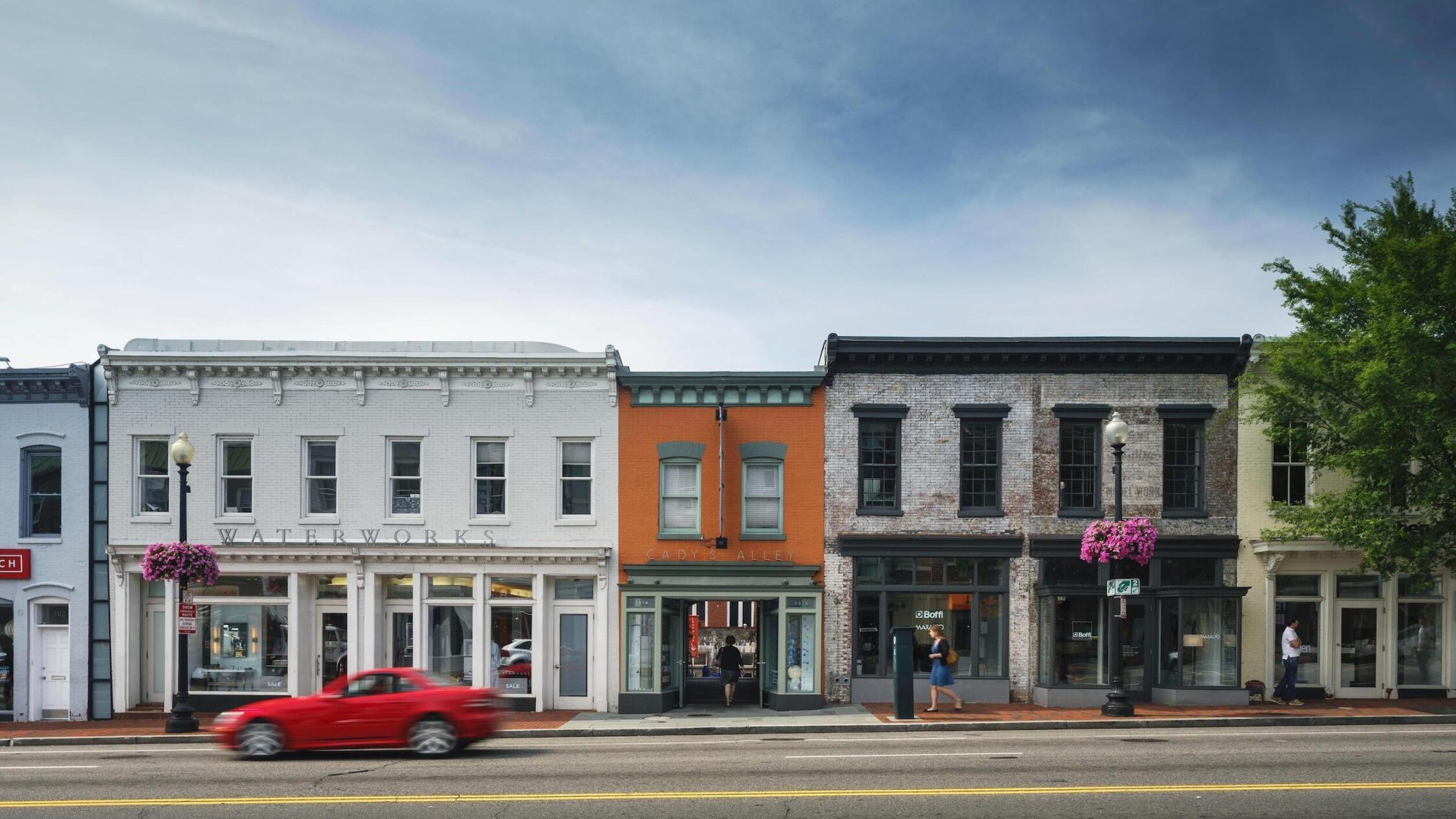 Street view of The Georgetown Renaissance Collection with a red car passing by