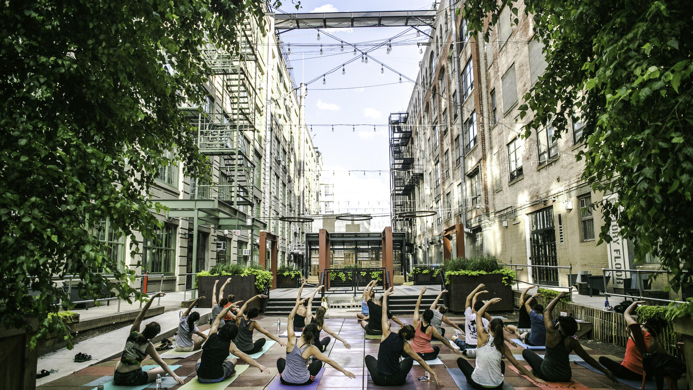 Industry City courtyard with guests practicing yoga at a class