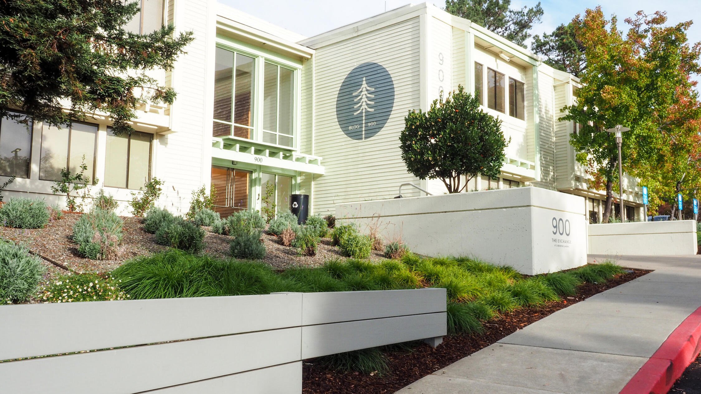 Exterior of The Exchange at Larkspur Landing with large trees under a clear sky