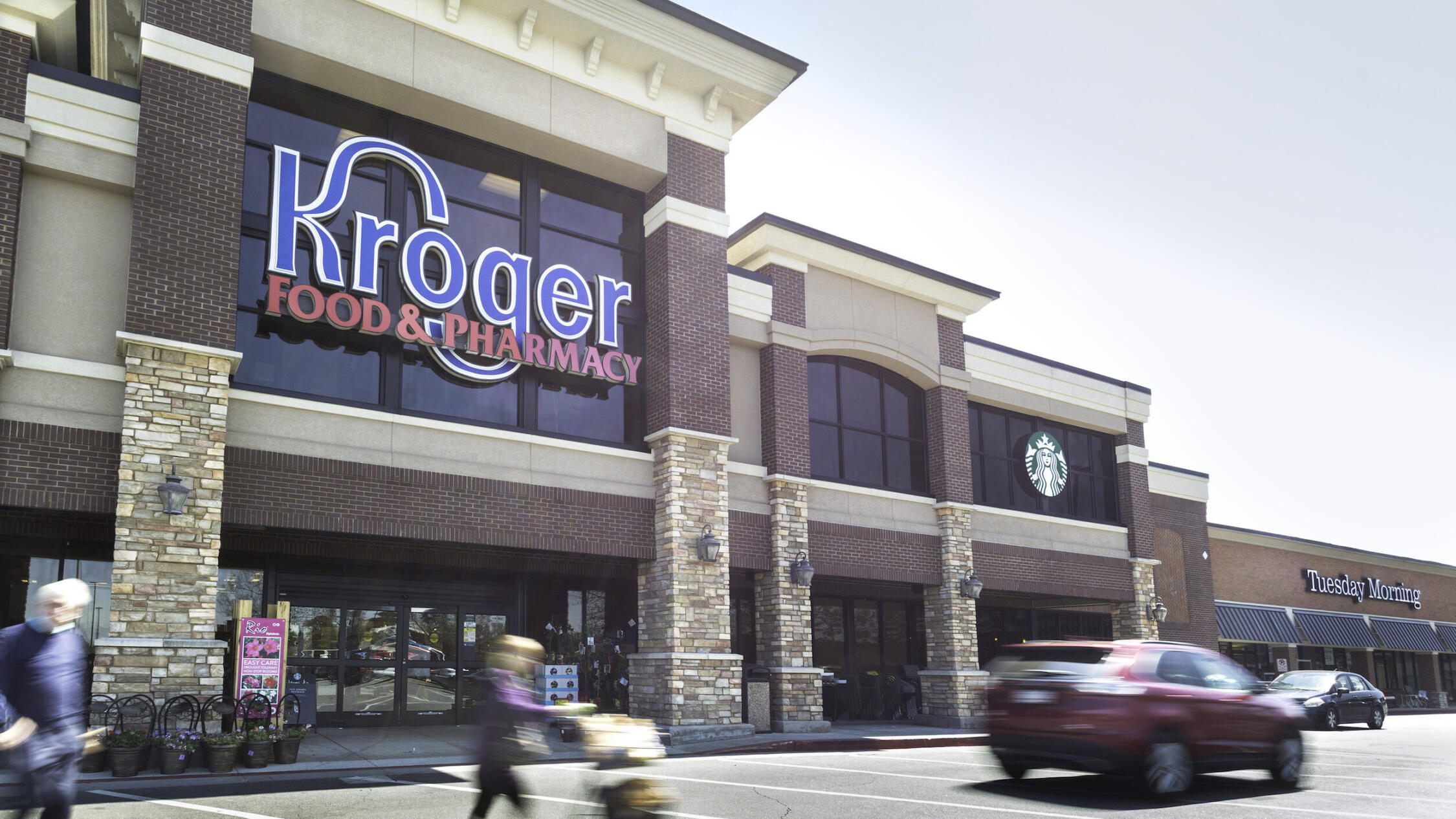 People and cars make their way by the Kroger Grocery Store at Parkaire Landing.