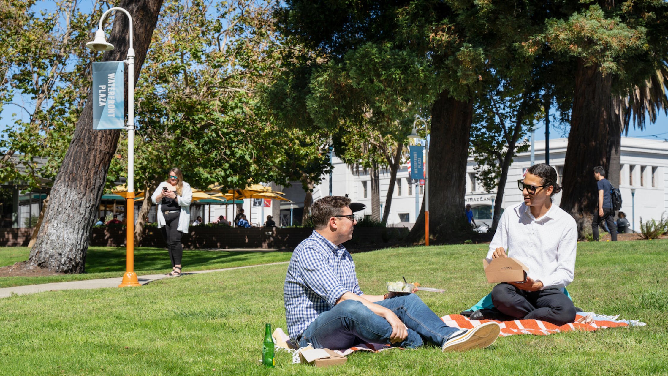 People sitting at a picnic outside Waterfront Plaza