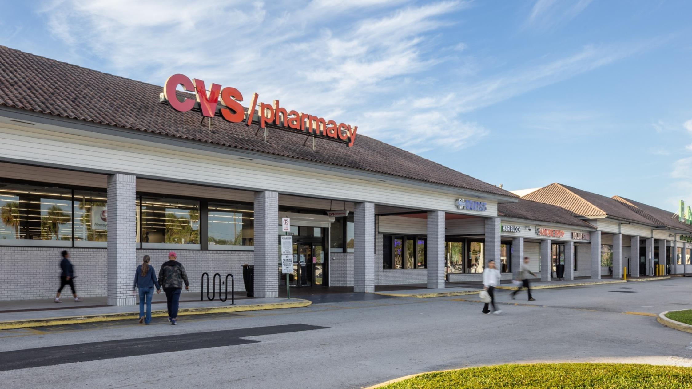 Exterior facade of a pharmacy store with pedestrians in driveway at Country Club Plaza