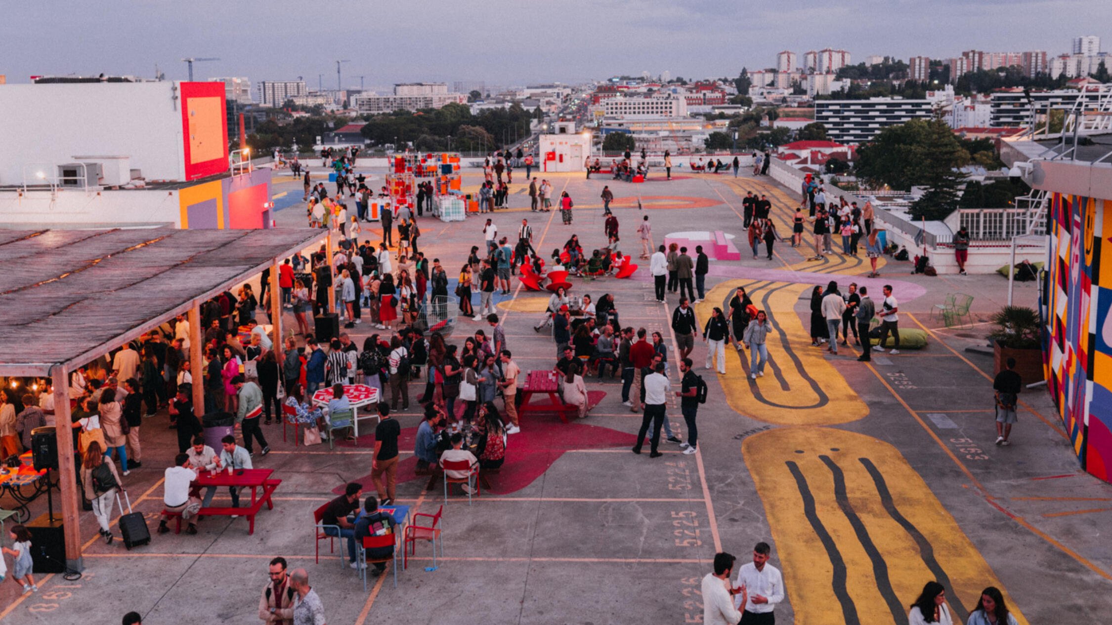 Dozens of attendees at an event on the IDB Lisbon rooftop