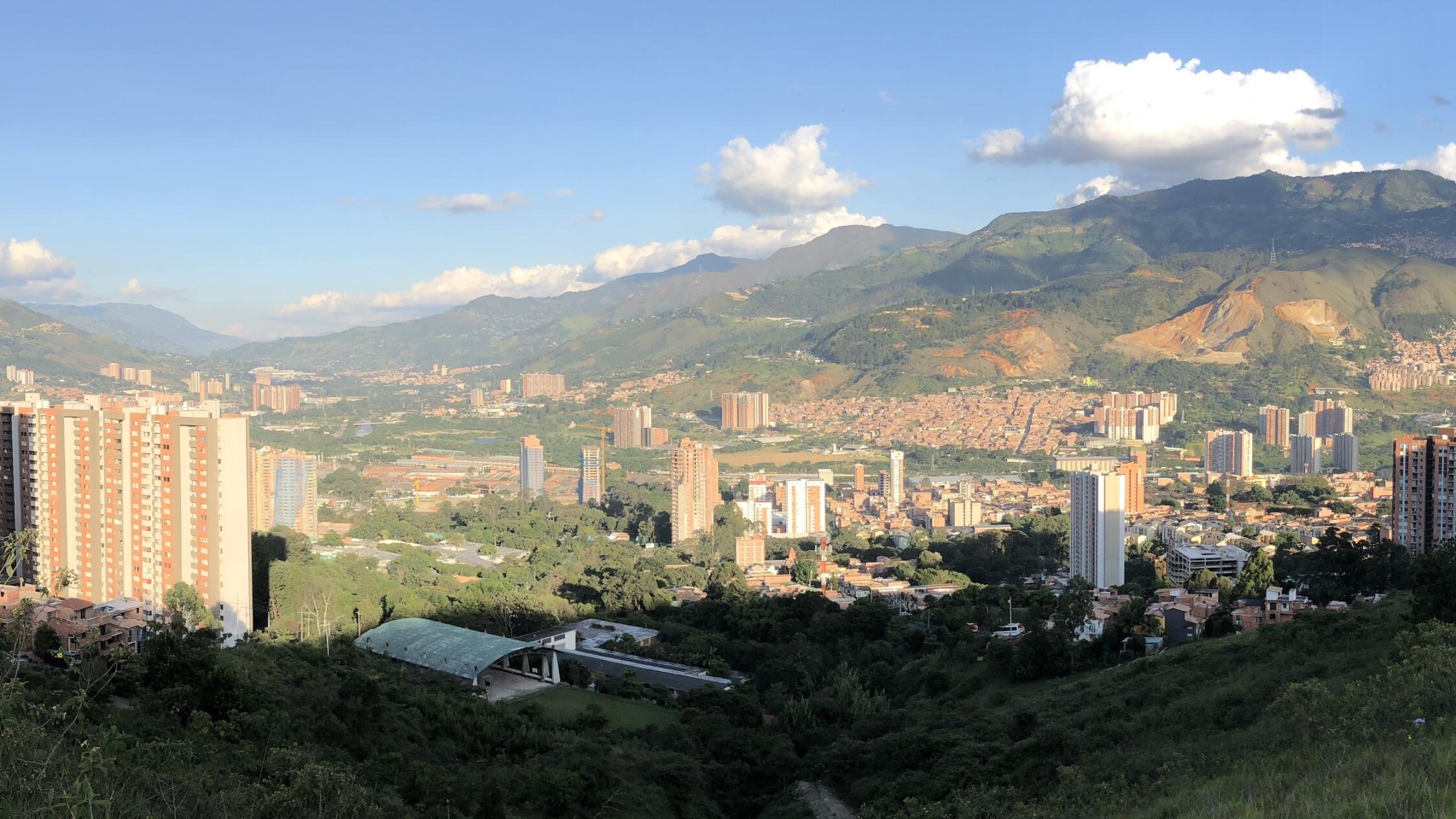 View of a green lush valley and buildings scattered throughout