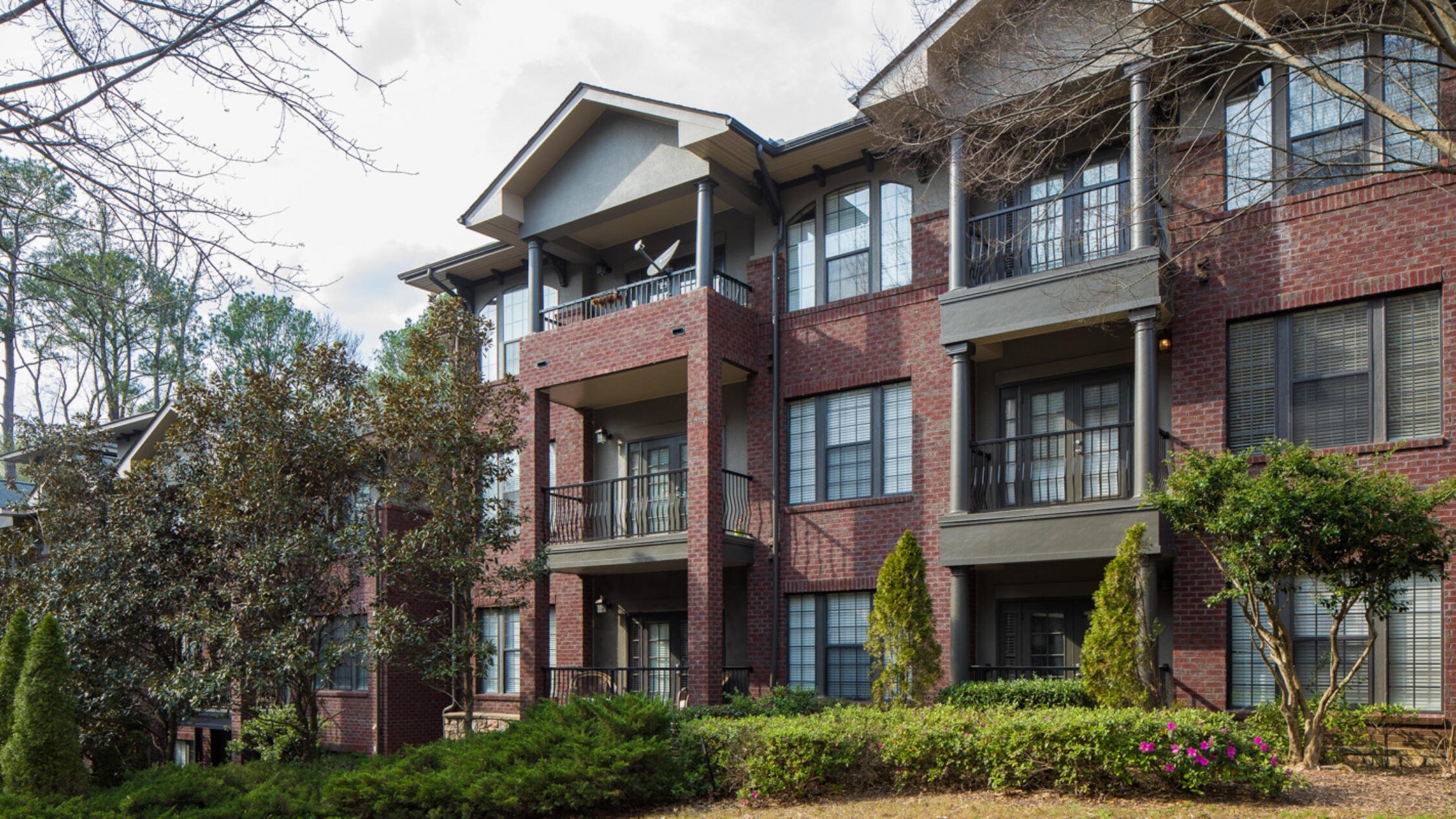 Rock Springs Village facade with trees and shrubs in foreground