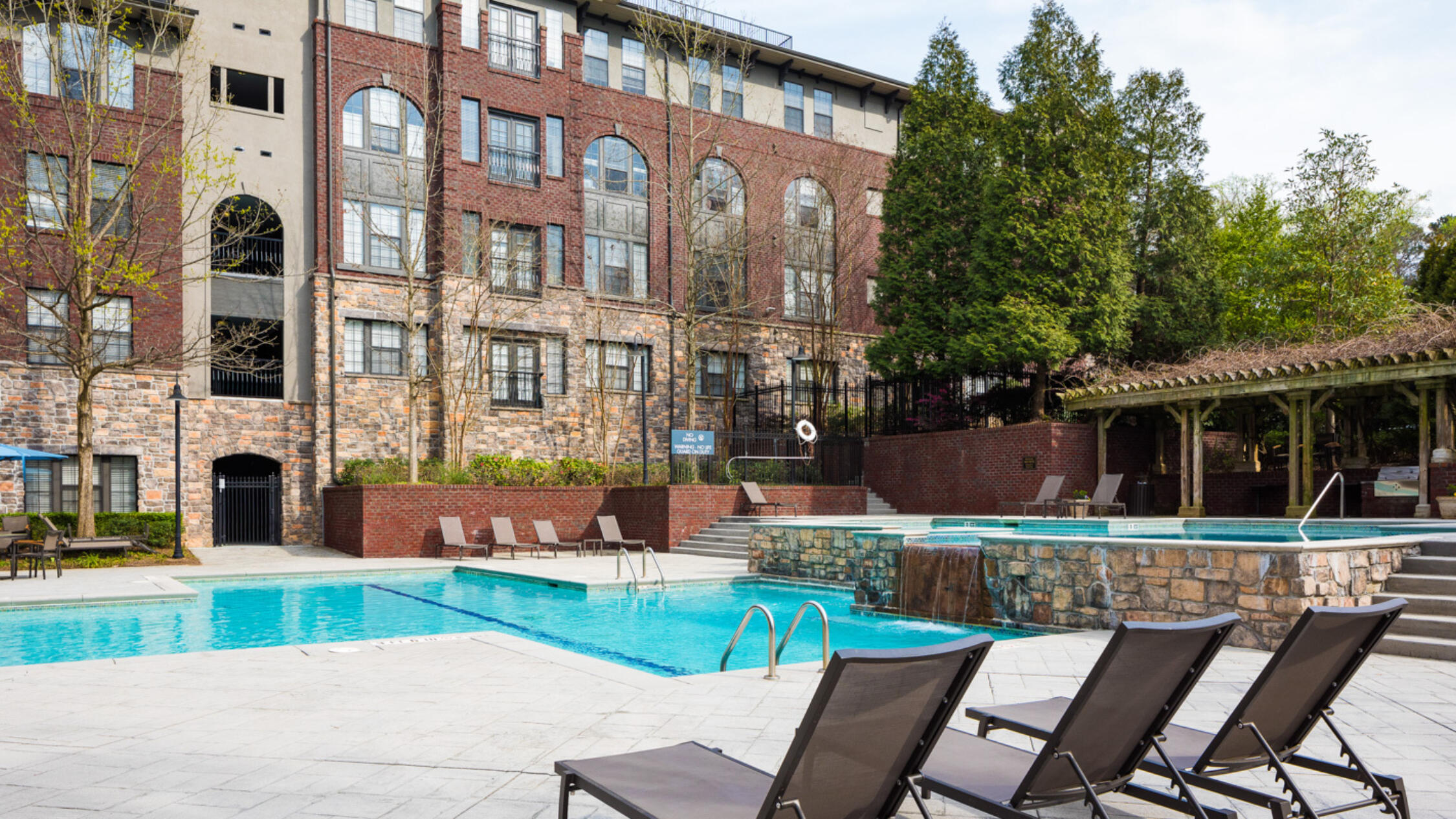 Rock Springs Village swimming pool with building in background and chaises longues in foreground