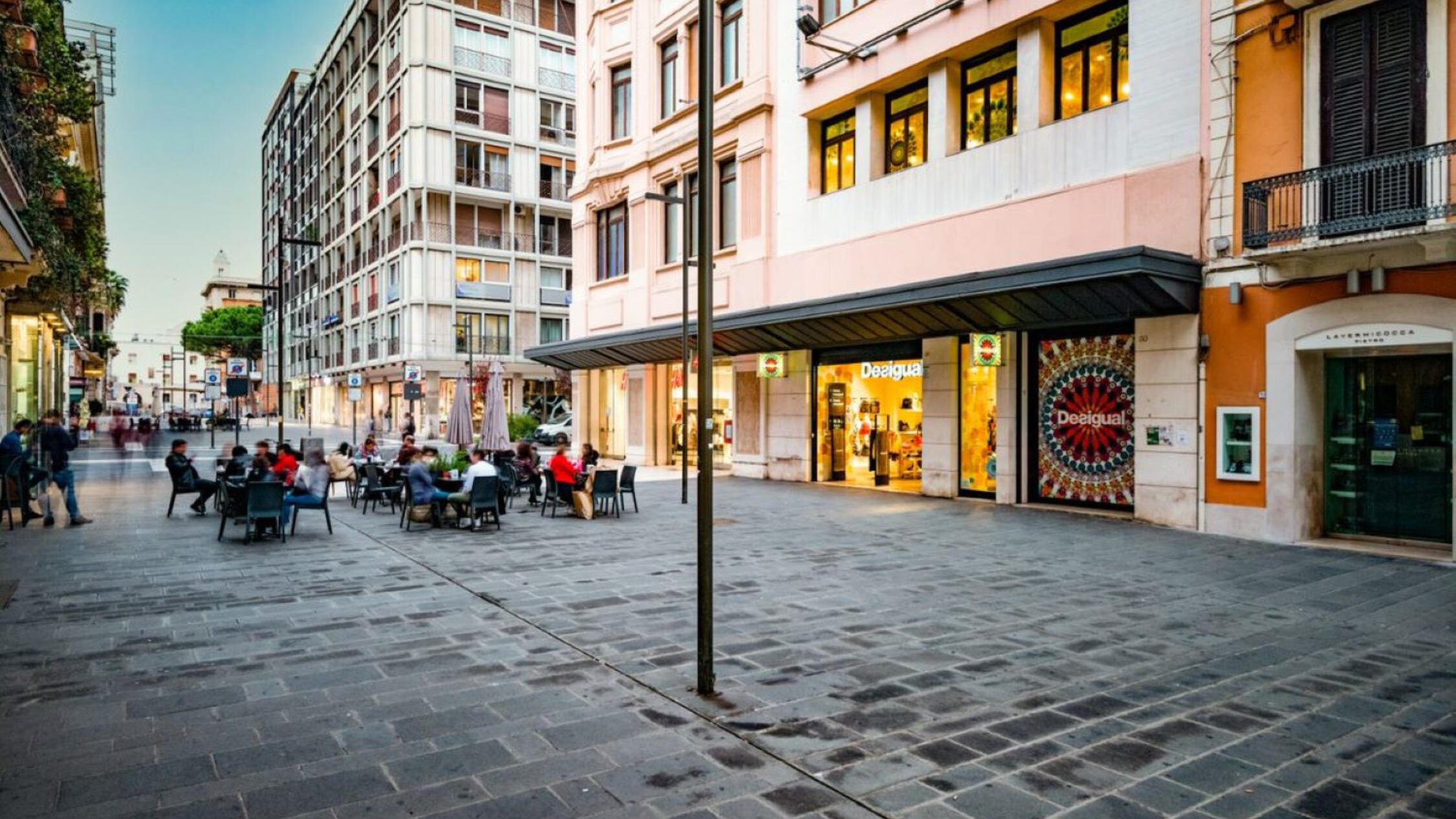 Via Sparano façade with visitors seated at tables on the street