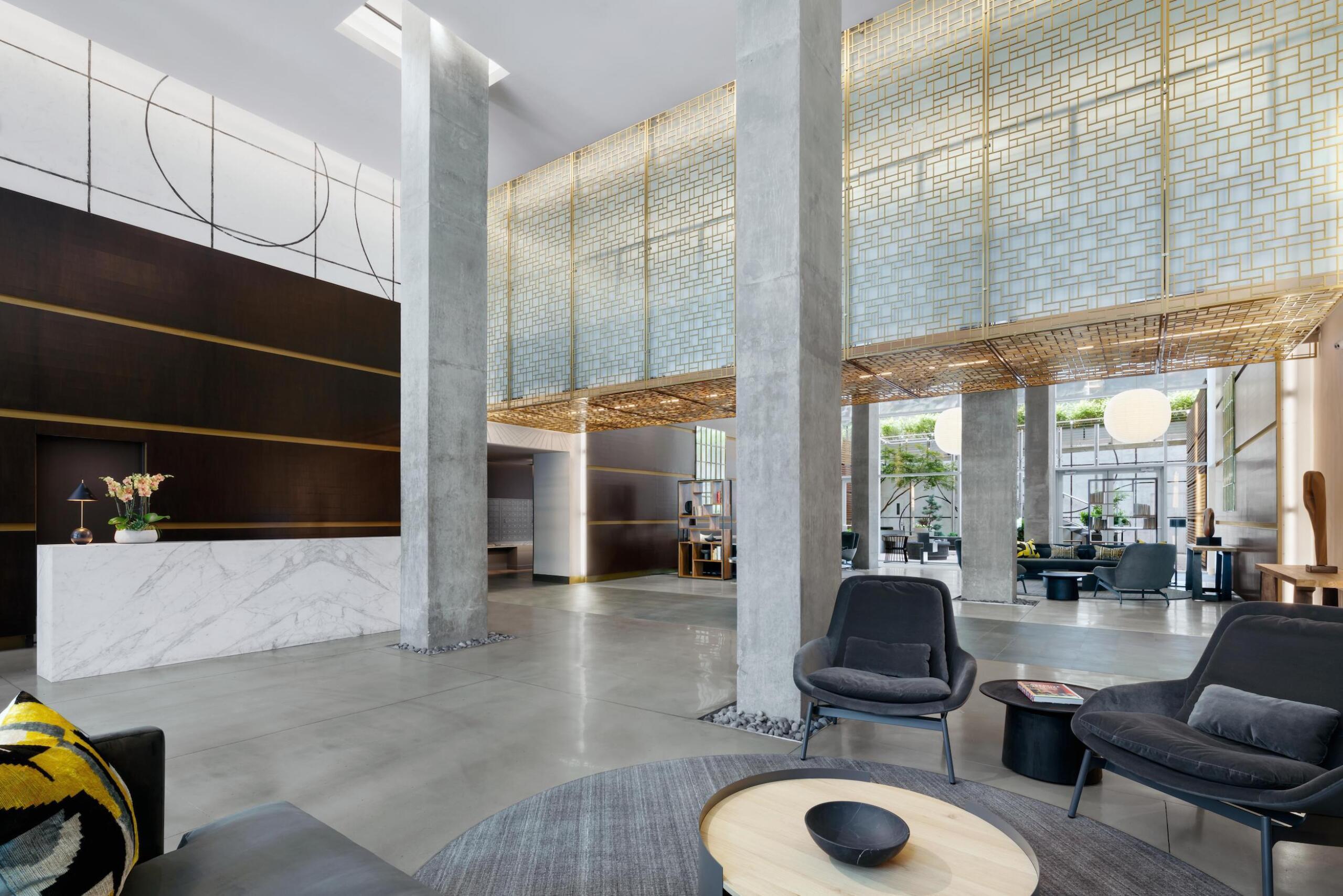 88 Leonard lobby with lounge area, concierge desk, and view of main entrance doors