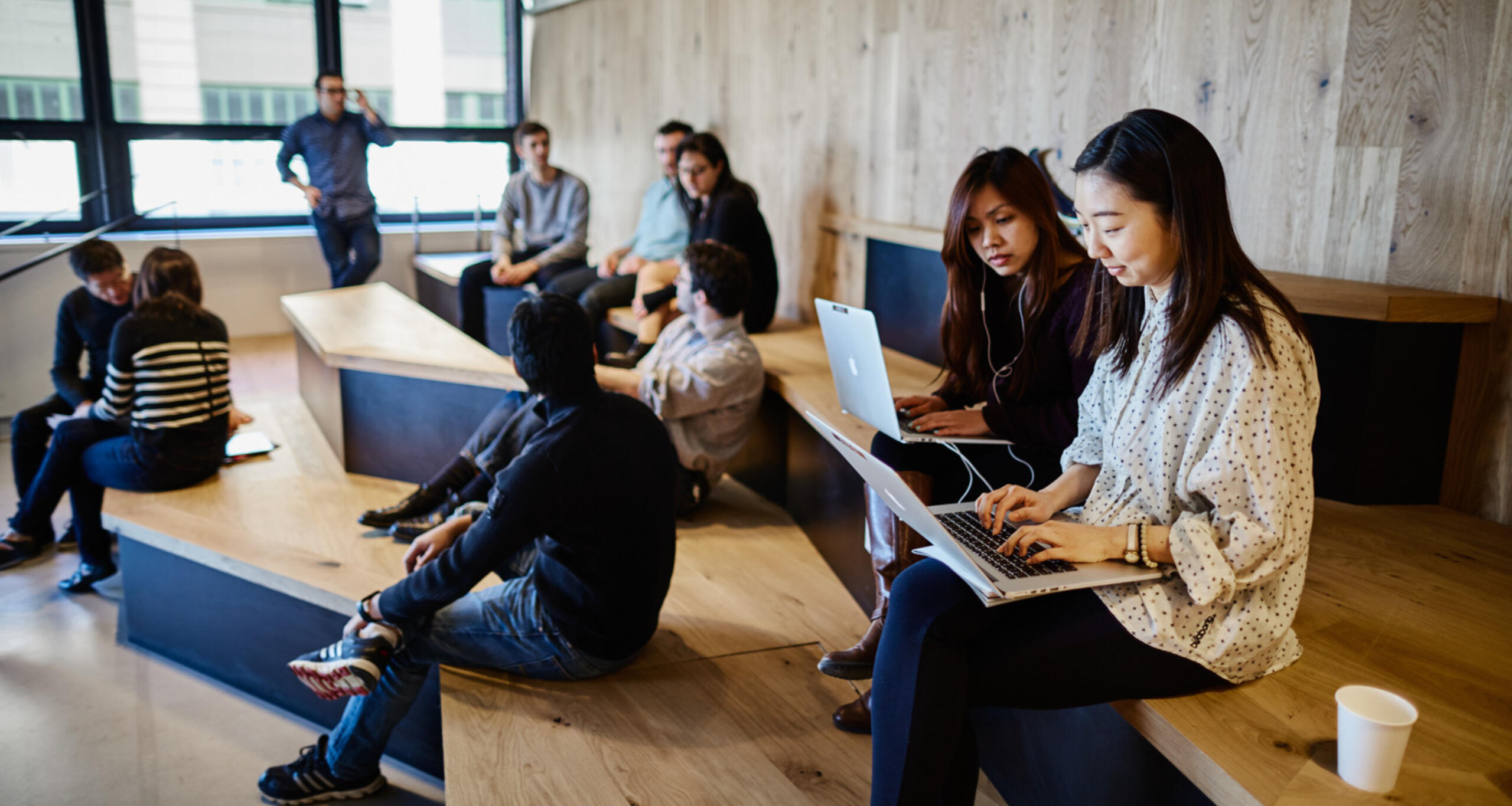 A group of people working and meeting in an office common area