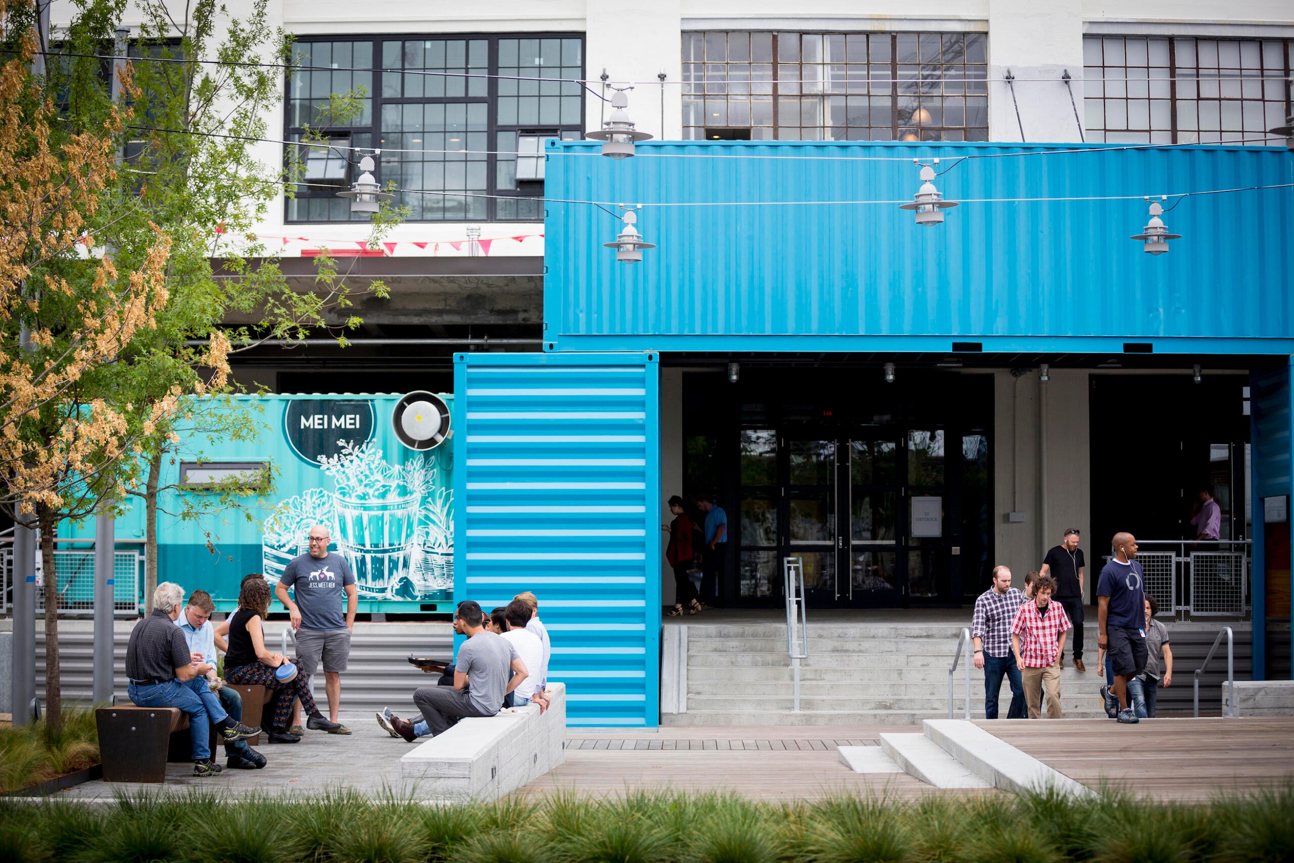 People outside in the common area at street level of The Innovation and Design Building