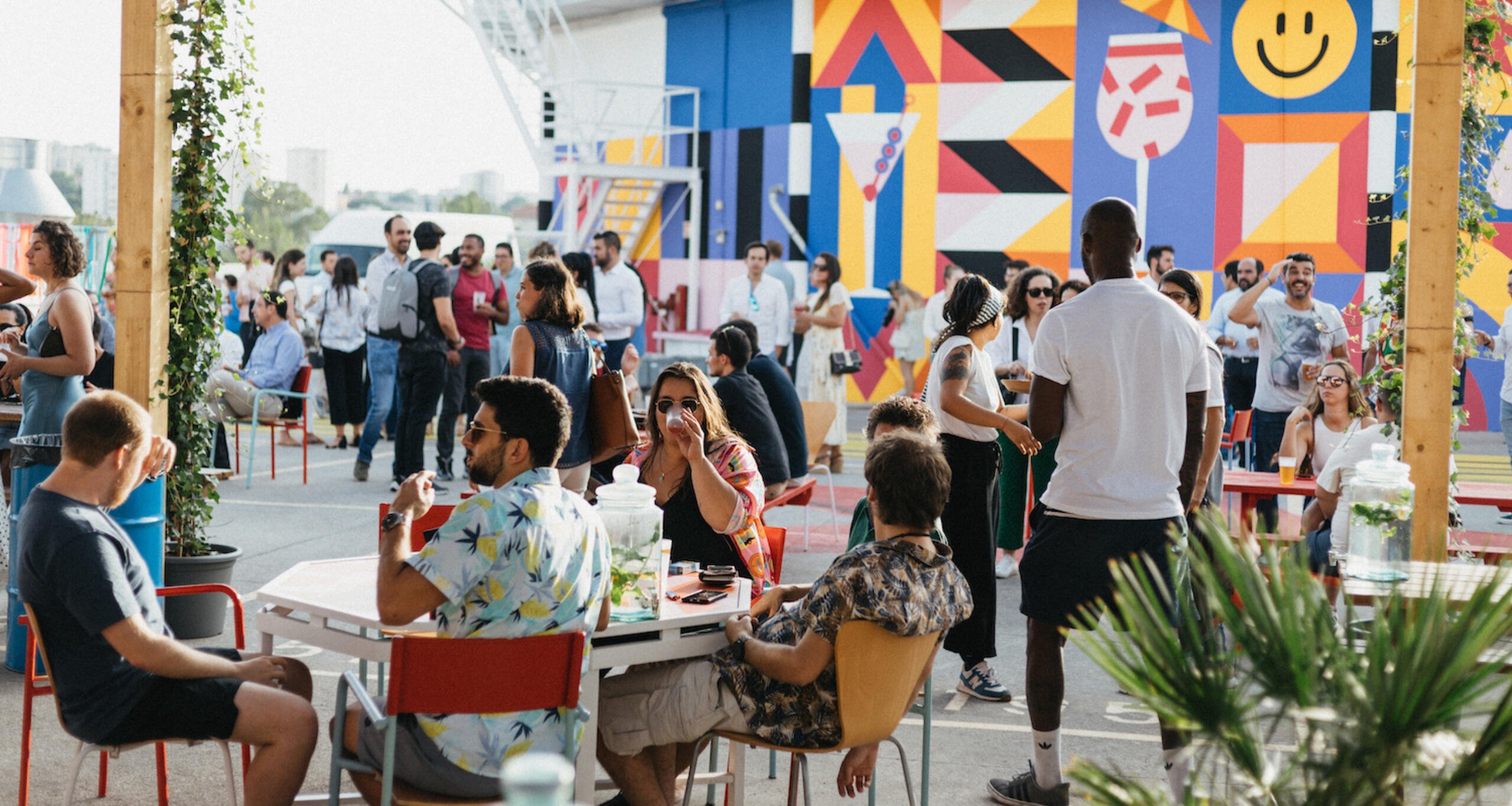 People talk and drink on the colorful rooftop of the Innovation & Design Building  in Lisbon