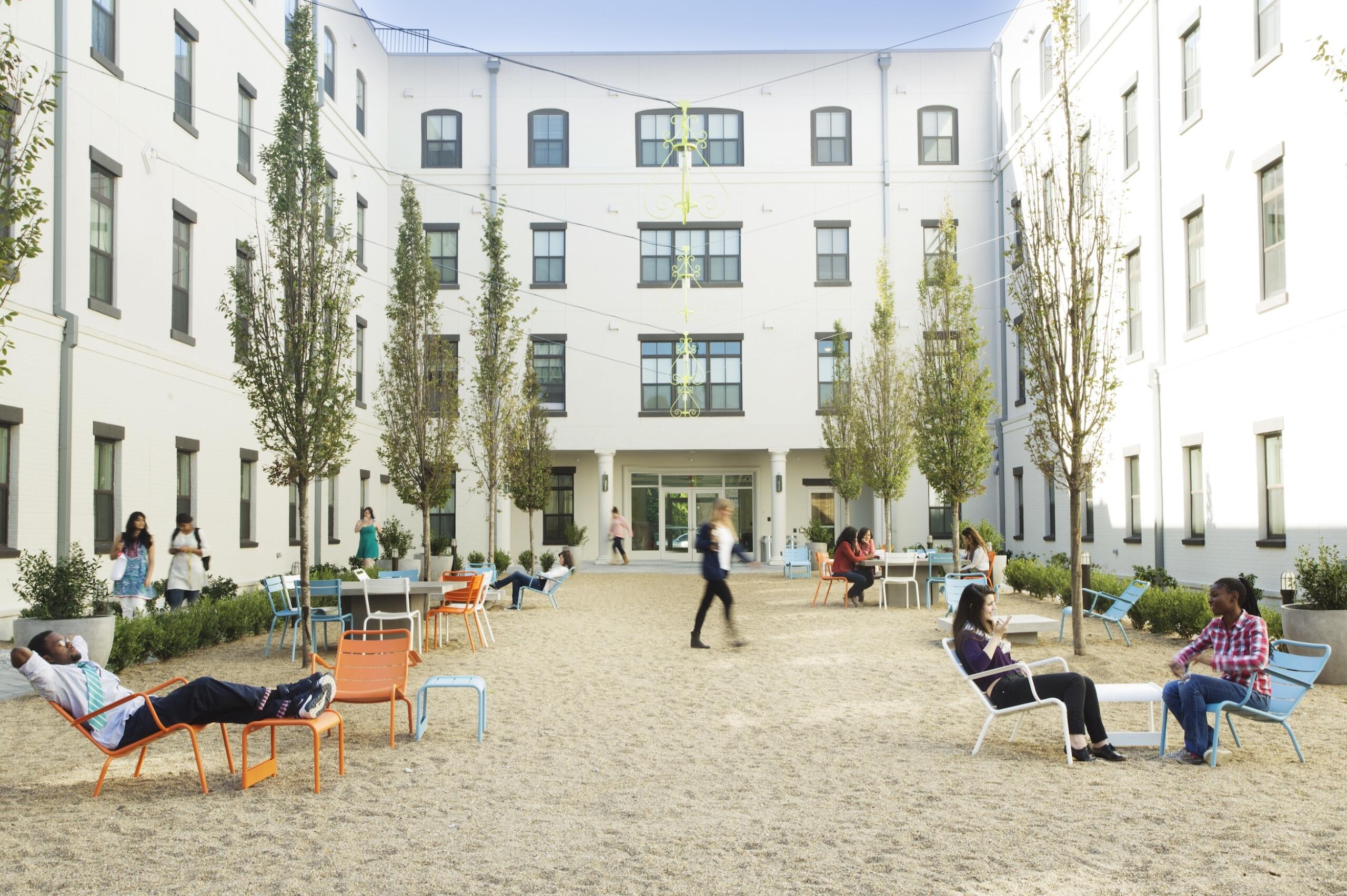 One West Victory courtyard with people seated in chairs in the sand