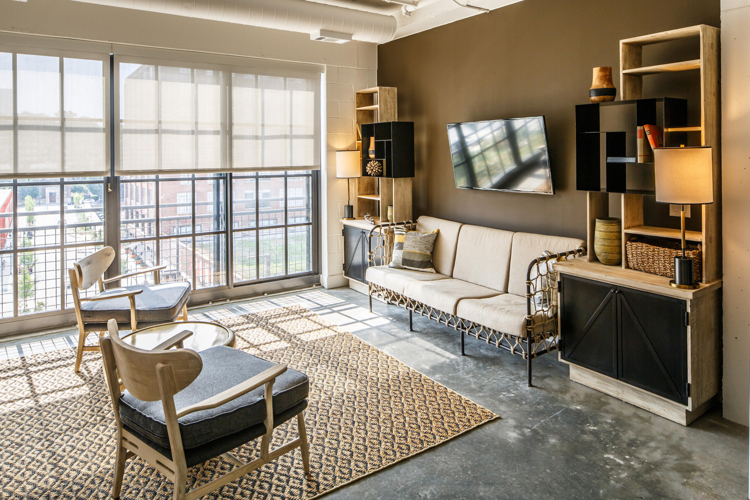 The Flats at Ponce City Market guest suite living area interior with view of building and green roof outside windows