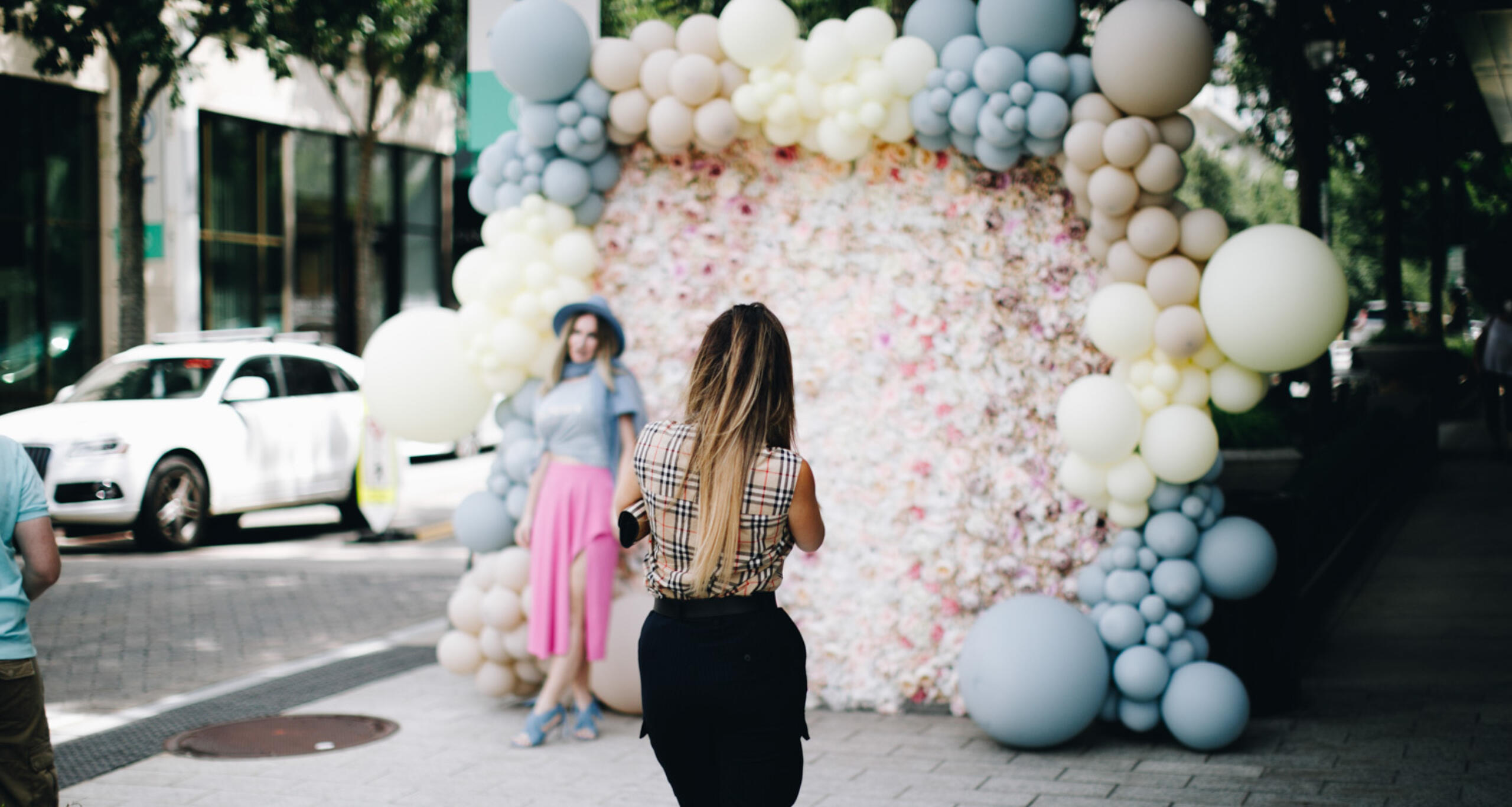 A woman posing for a photograph in front of a huge outdoor floral installation at Buckhead Village District