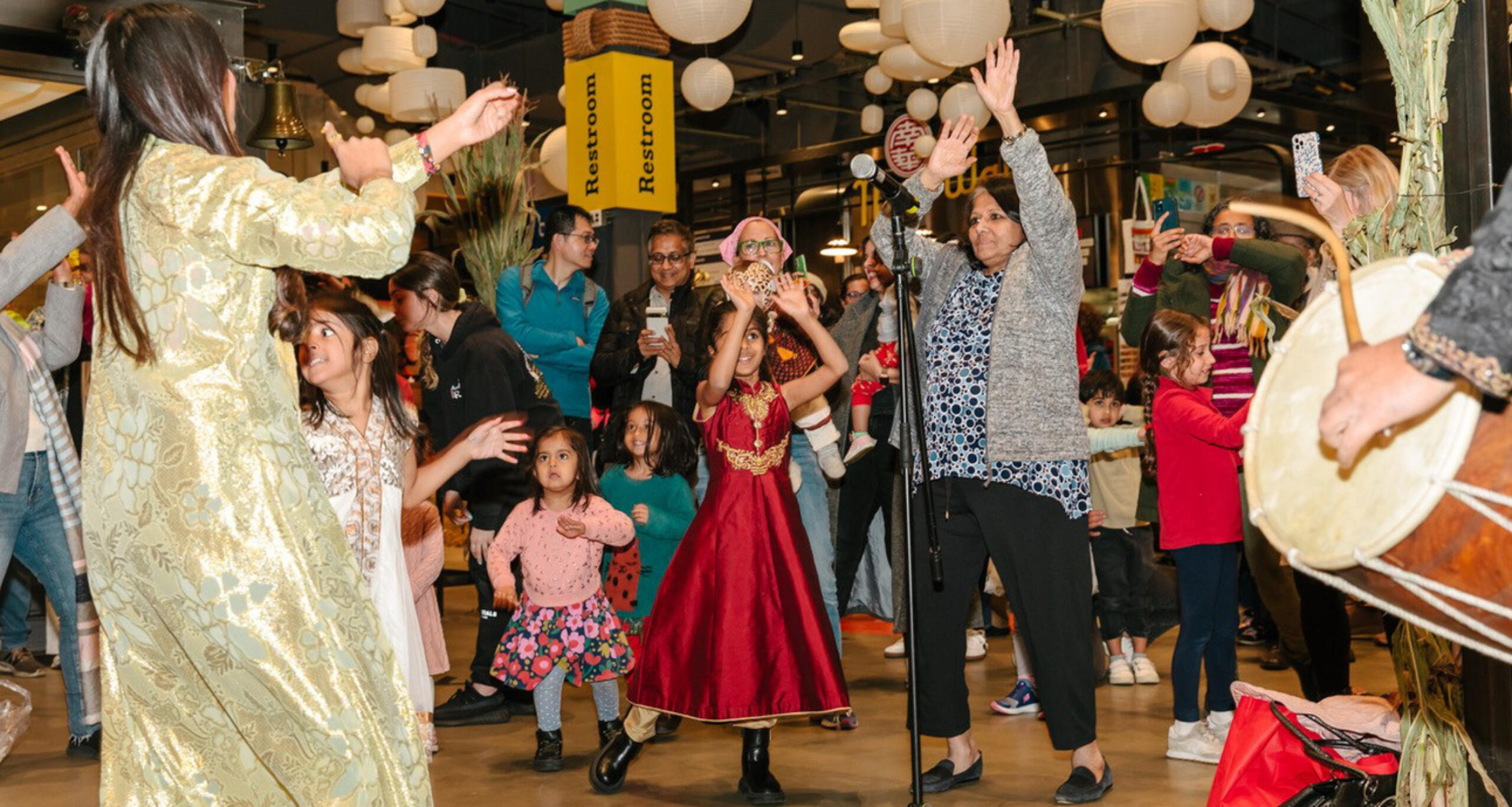 A multi-generational group dancing to celebrate Diwali inside Pier 57