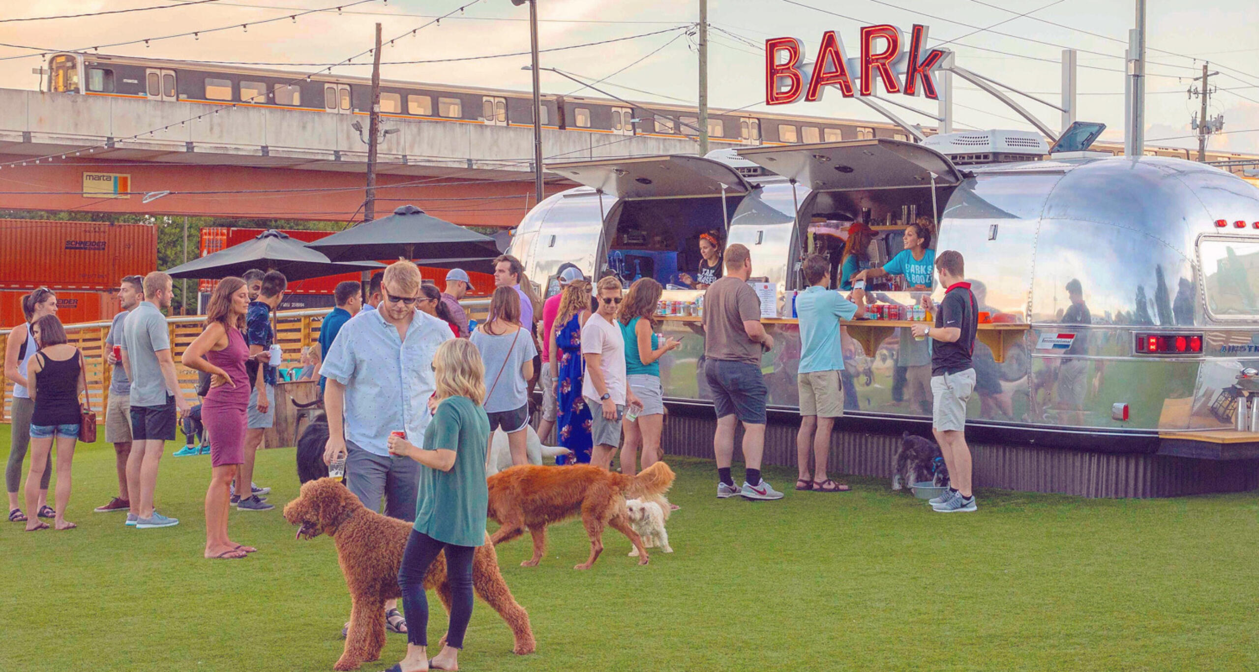Fetch Park Buckhead with dogs and people visiting an Airstream trailer vending food