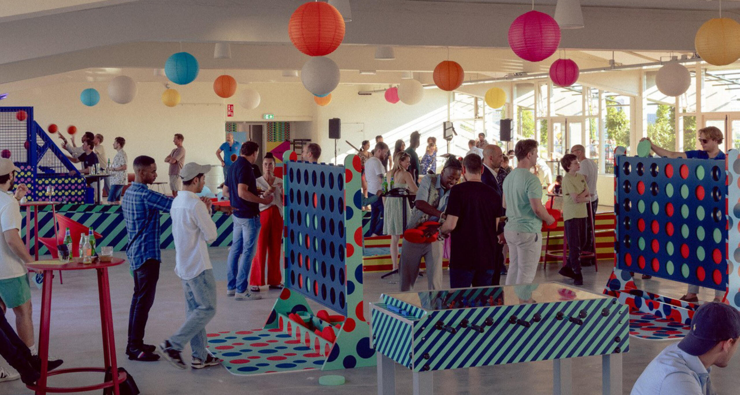 Crowd of people playing large-format games in Groot Handelsgebouw Rooftop's indoor common area