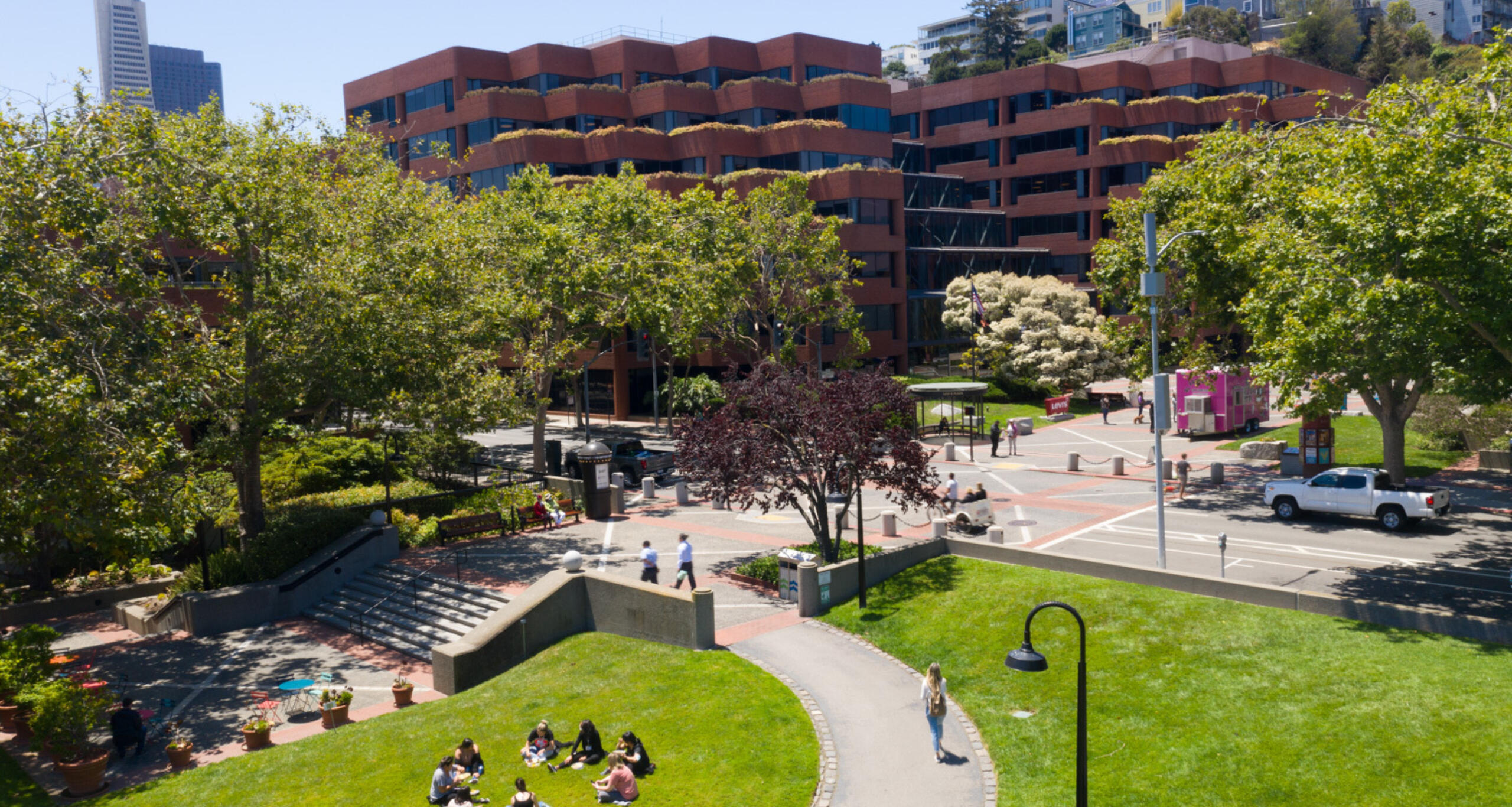 Levi's Plaza exterior with people gathering in greenspace in front of building