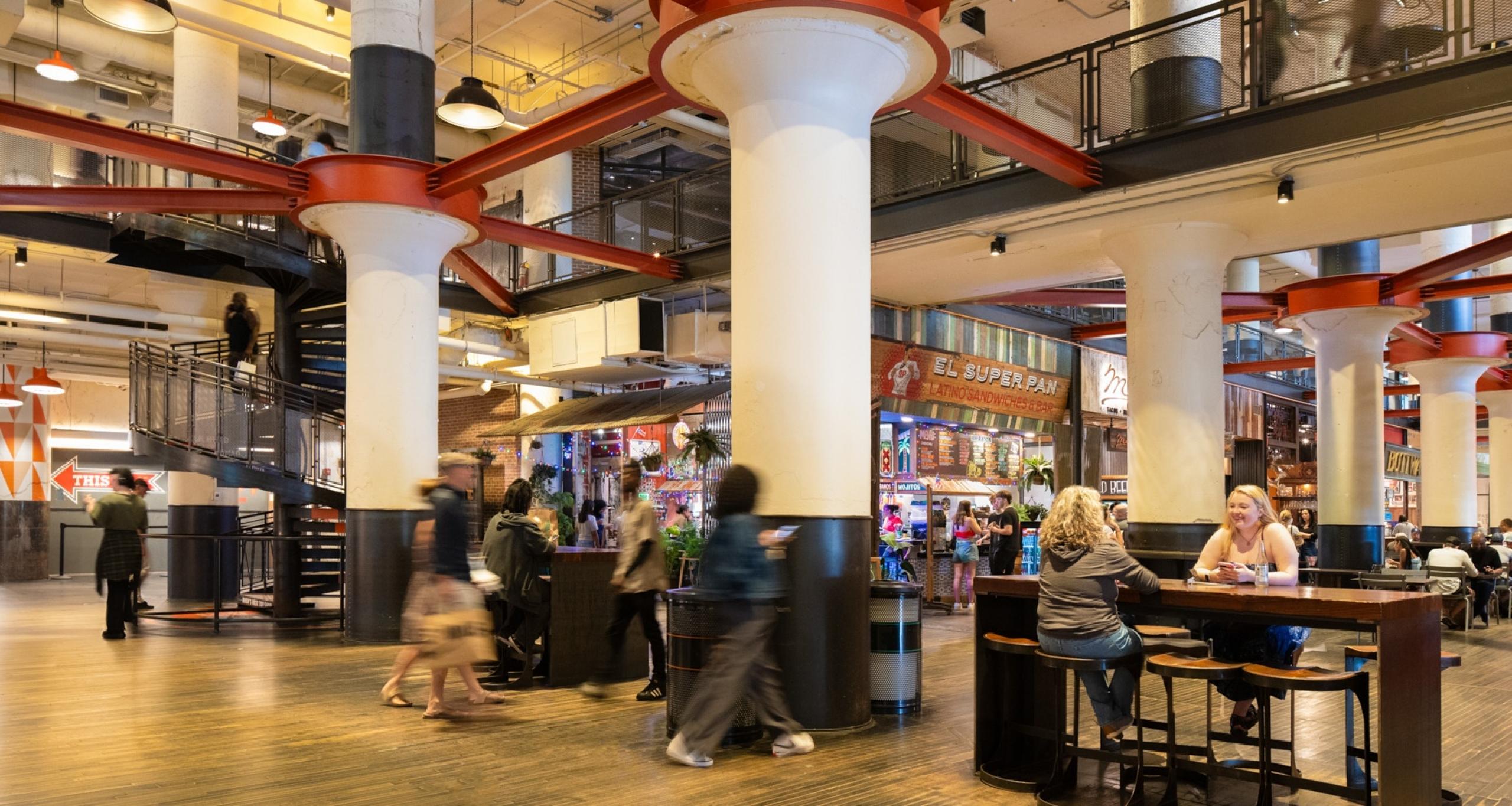 Visitors sitting at tables and walking inside Ponce City Market's Central Food Hal