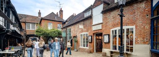 Visitors walking on a cobblestone street at the historic retail and residential property