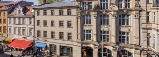 Building facades along Oranienburger Straße with people walking on sidewalk