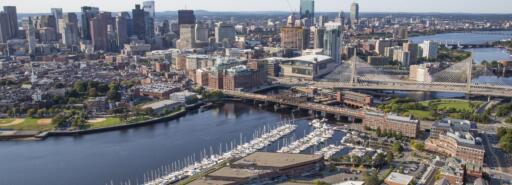 Aerial of Constitution Wharf building, marina, and river, with Boston skyline in background