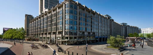 People walk around outside Groot Handelsgebouw