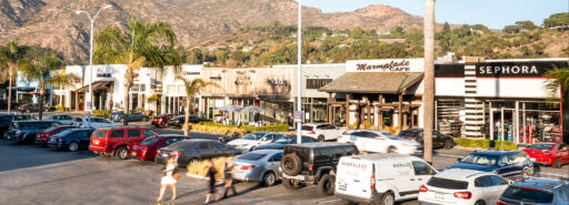 People walk through the parking lot at sunset in Malibu Village